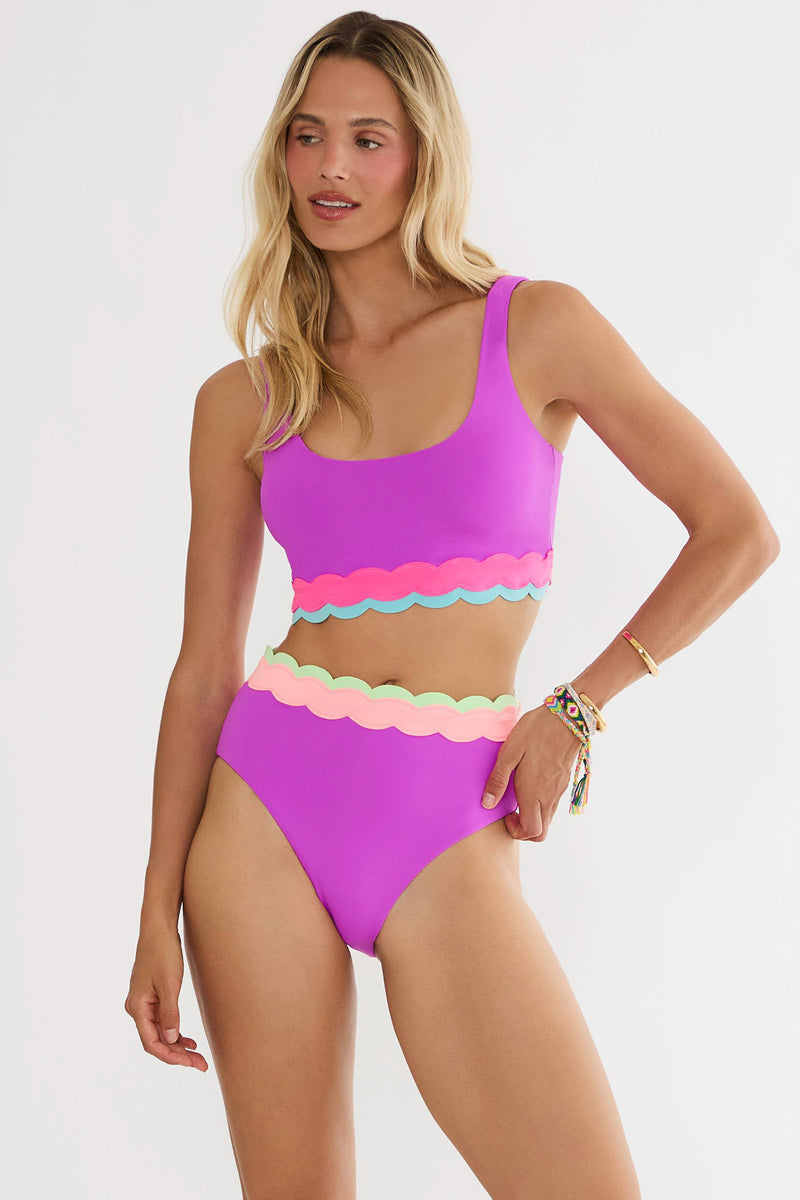 Woman wearing a colorful bikini with a white background