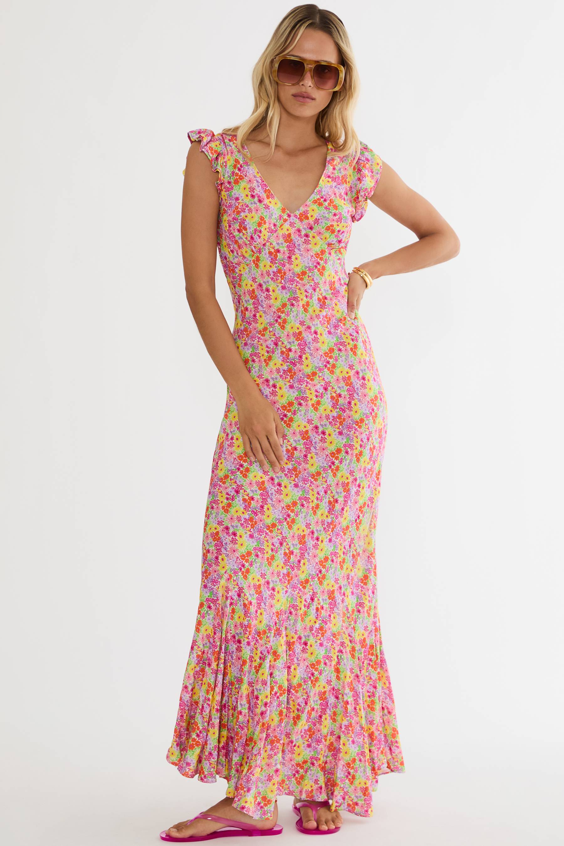 Woman wearing a colorful floral dress on a white background