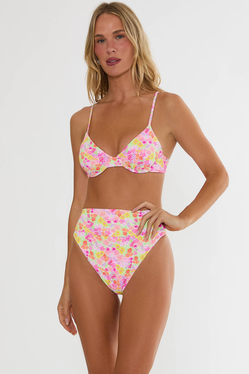 Woman wearing a colorful floral bikini set on a white background