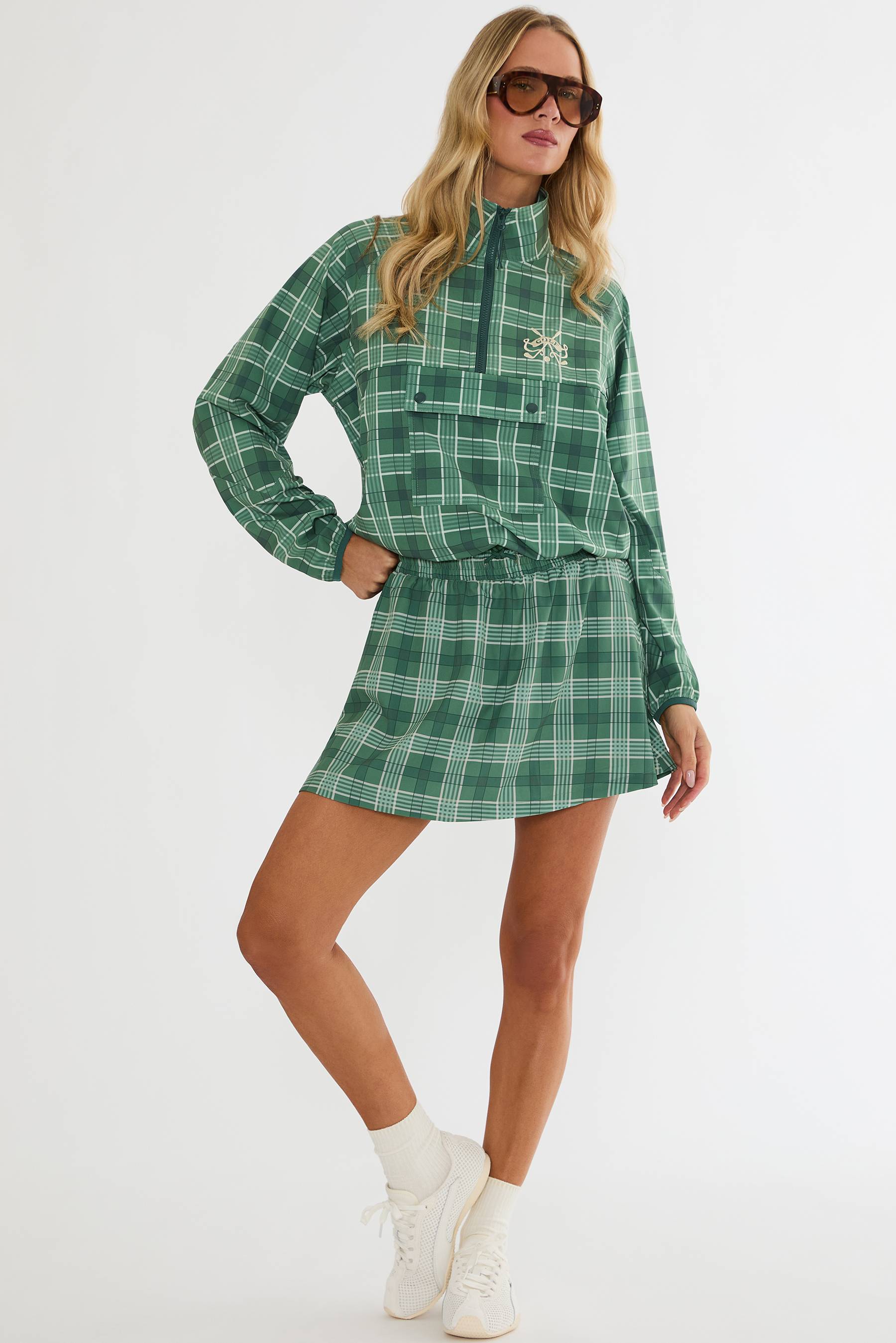 Woman wearing a green plaid dress with a white background