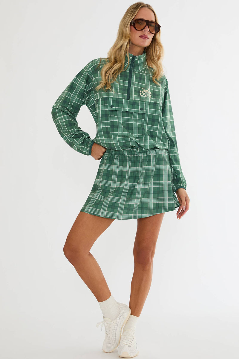 Woman wearing a green plaid dress with a white background