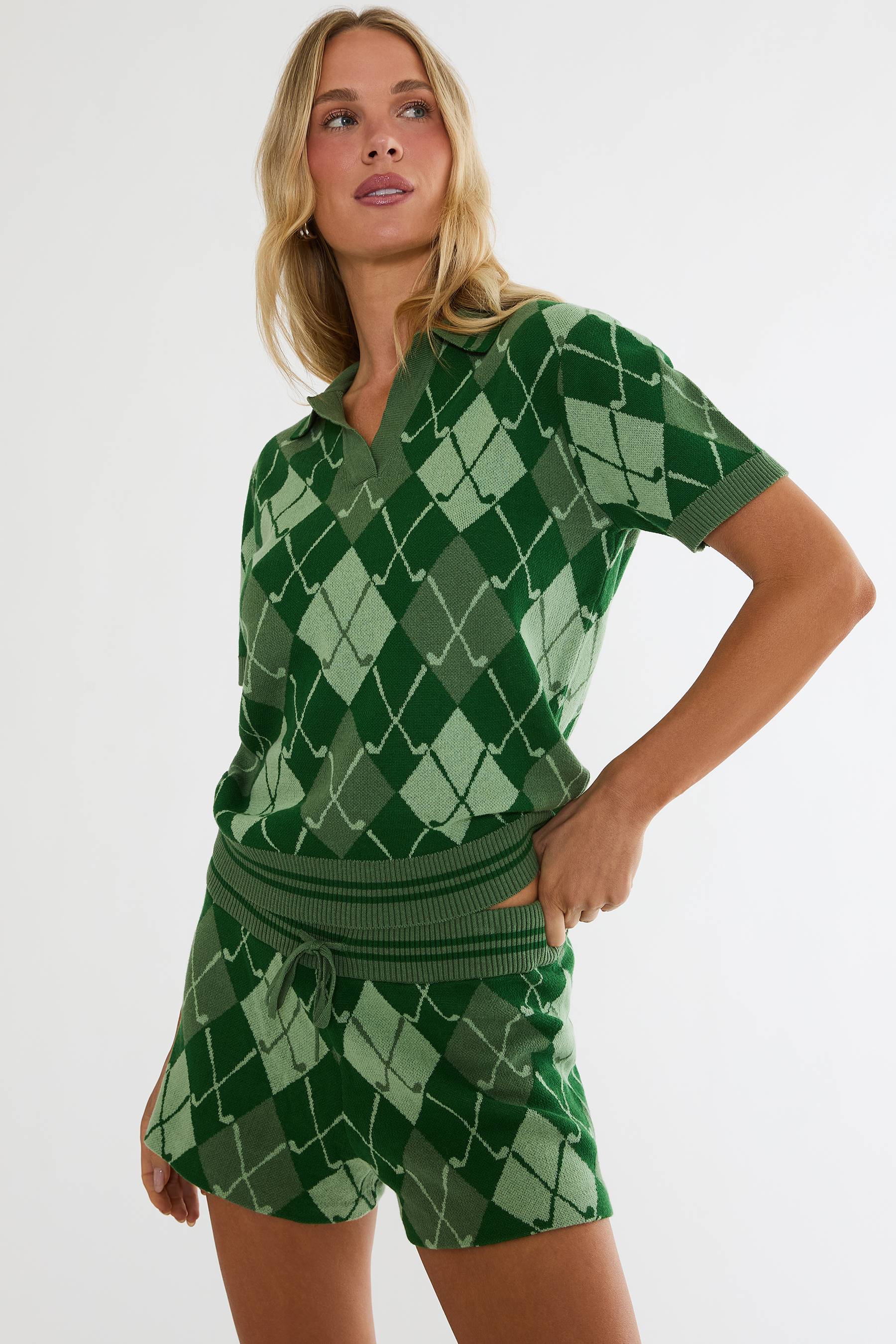 Woman wearing a green argyle patterned outfit on a white background