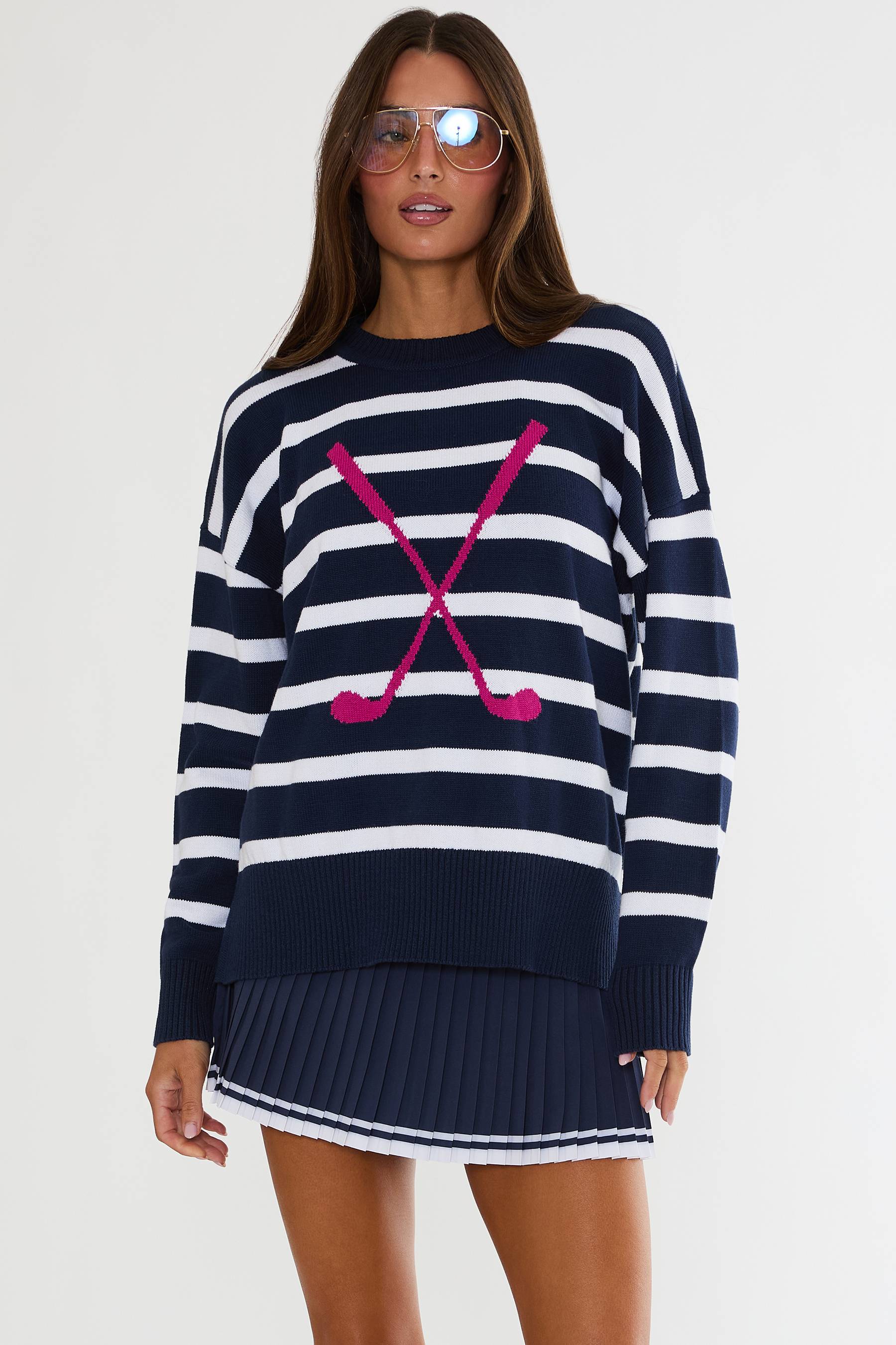 Woman wearing a navy and white striped sweater with a pink design on a white background