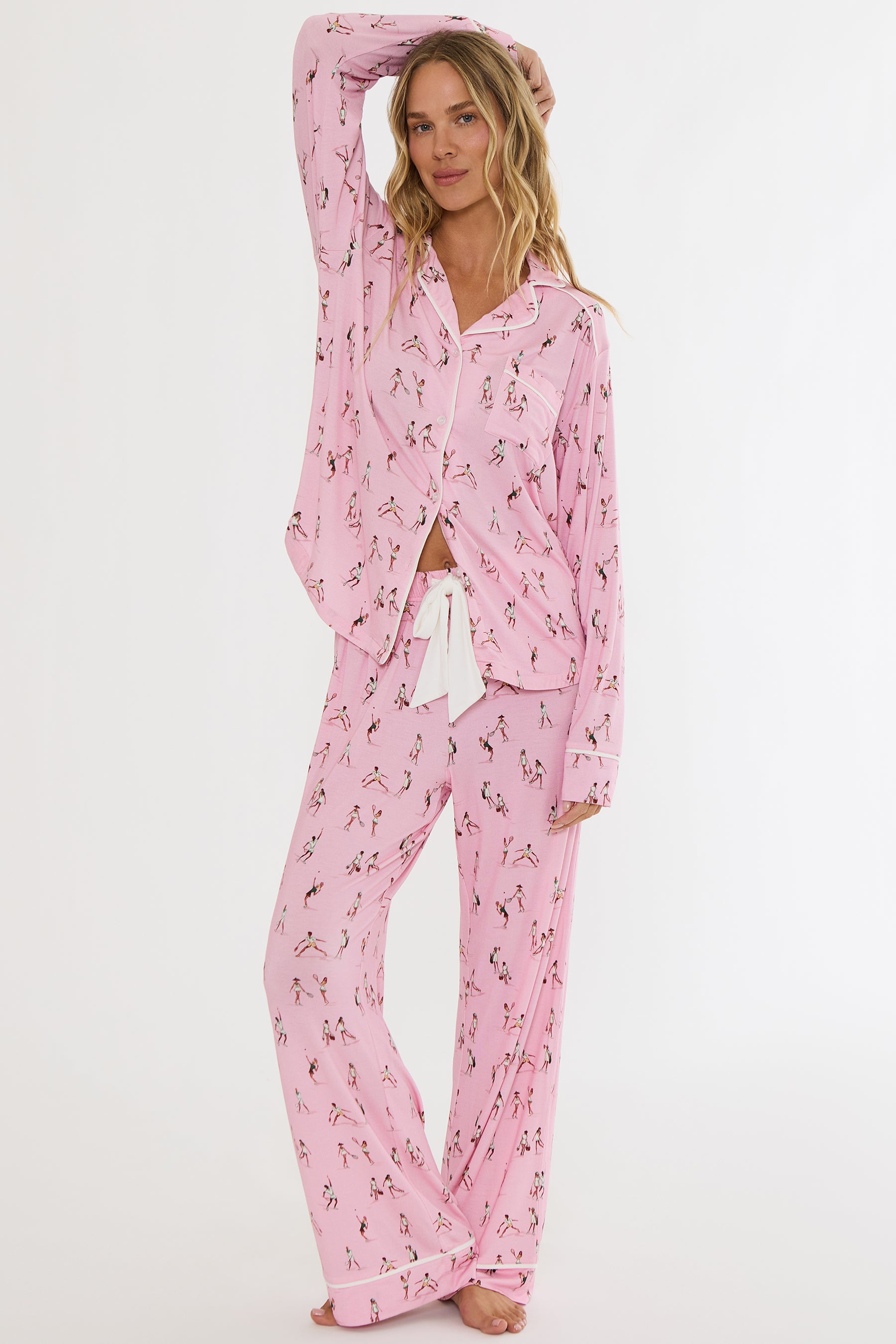 Woman wearing pink pajama set with floral pattern on a white background