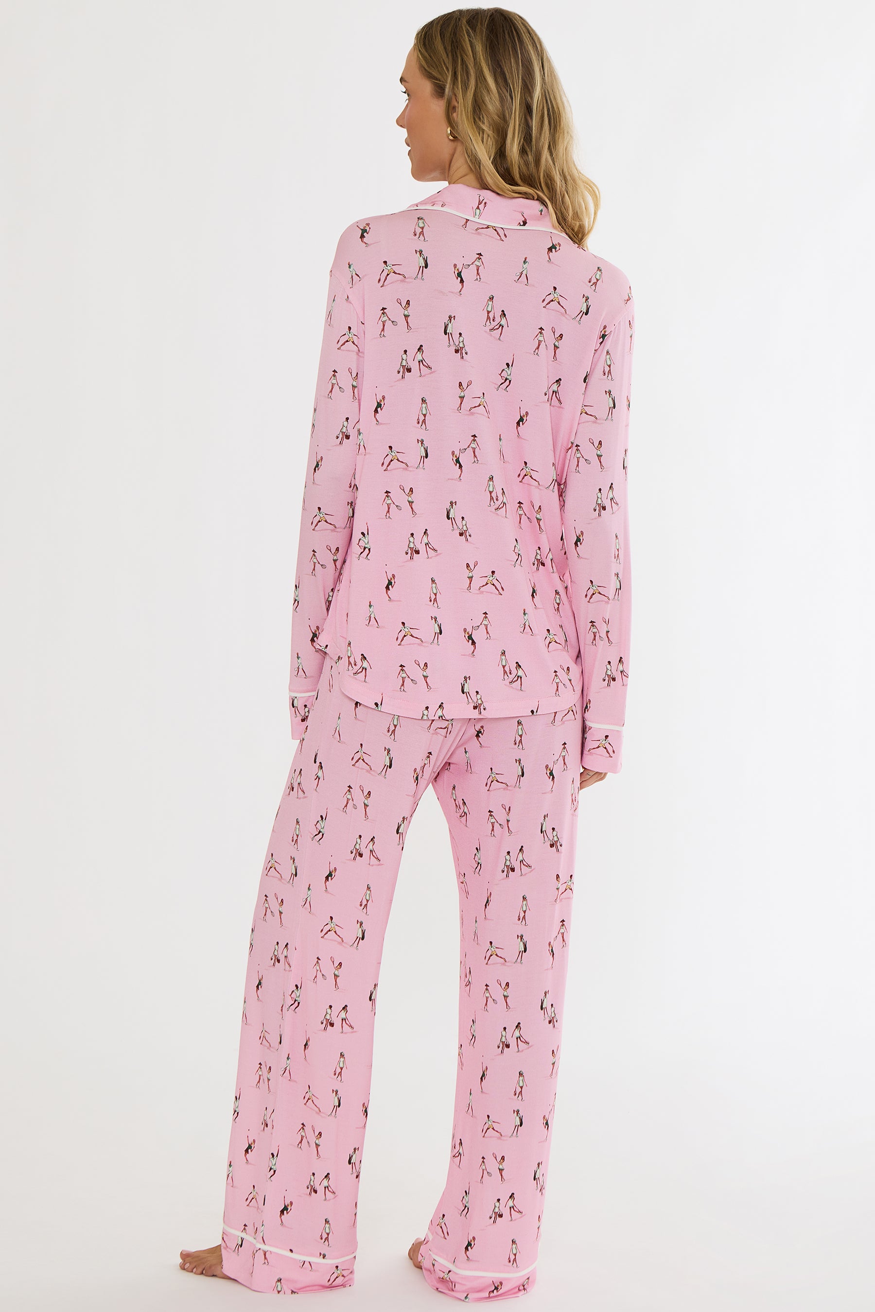 Woman wearing pink pajamas with a dog pattern on a white background