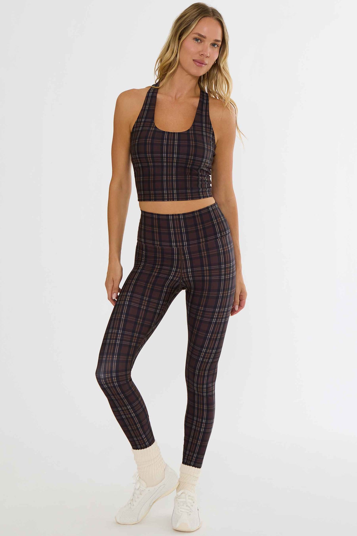 Woman wearing brown plaid workout leggings. 