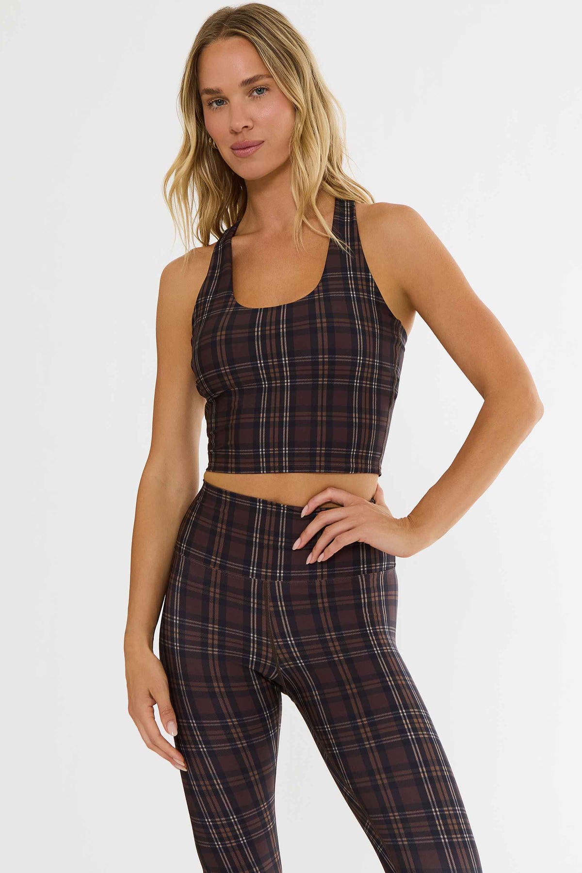 Woman wearing brown plaid racerback workout tank. 