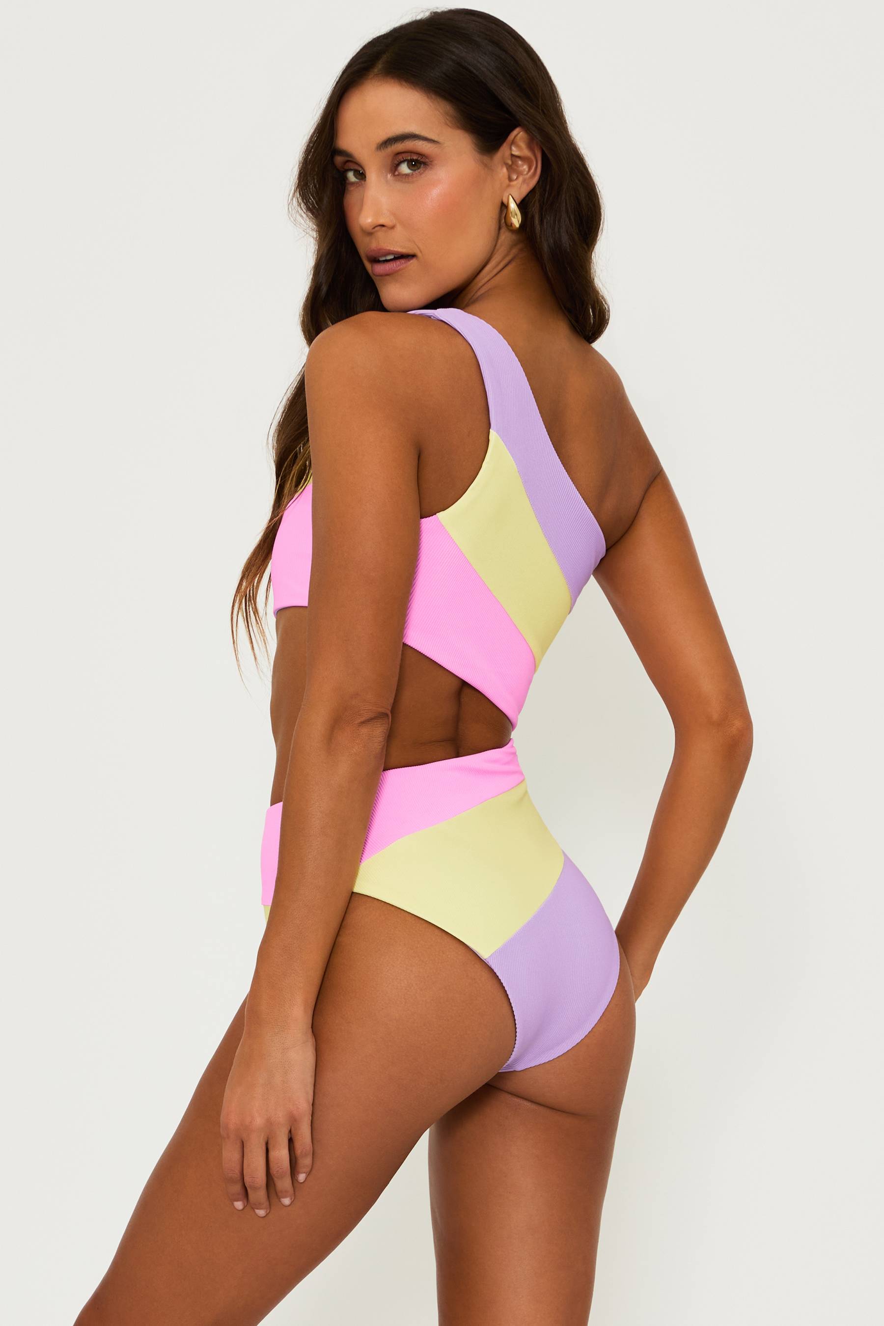 Pink, yellow and purple ribbed one piece swimsuit with one strap and a cut out detail