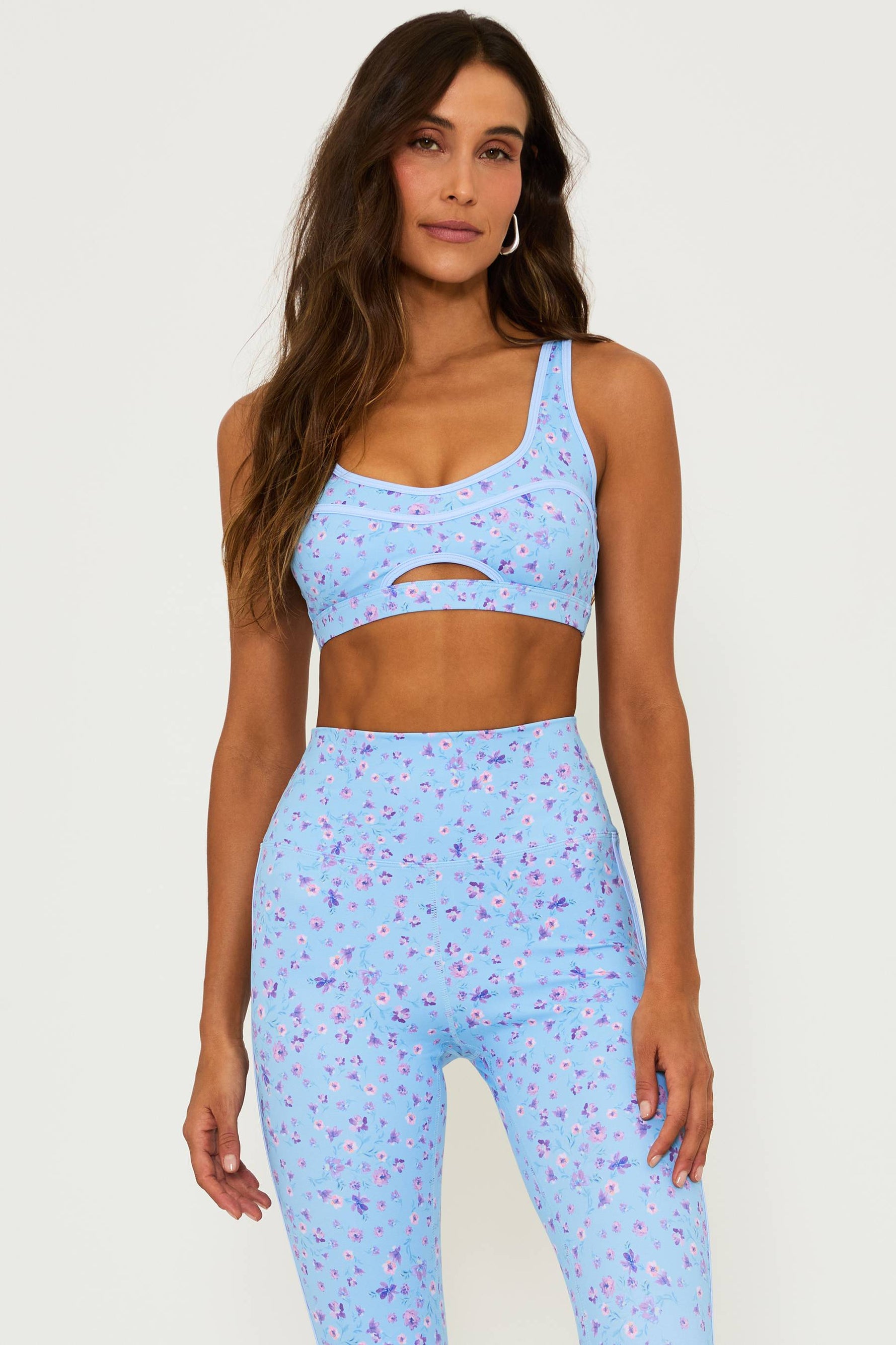 blue high waisted legging with a floral print and a matching sports bra with a cut out detail