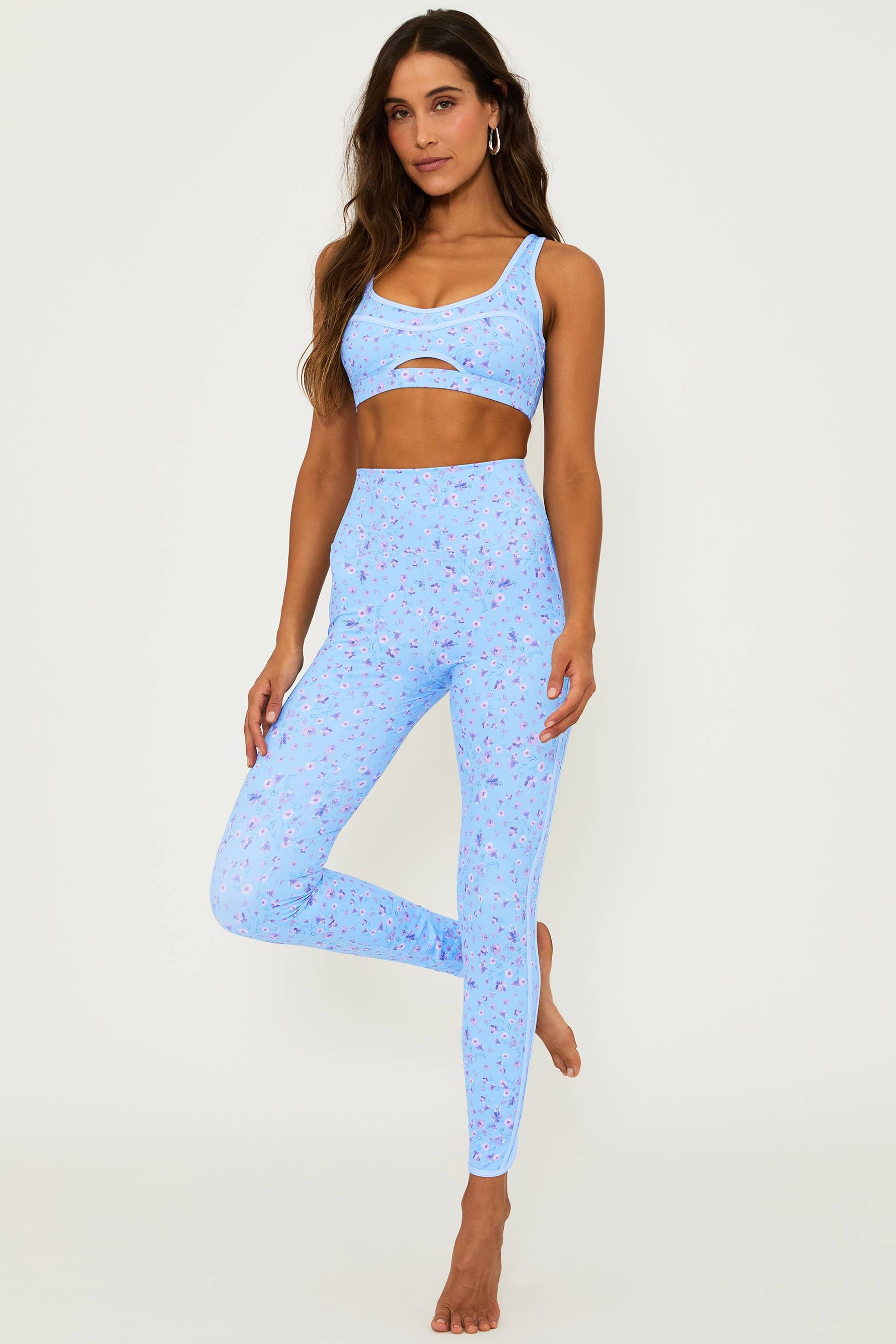 blue high waisted legging with a floral print and a matching sports bra with a cut out detail