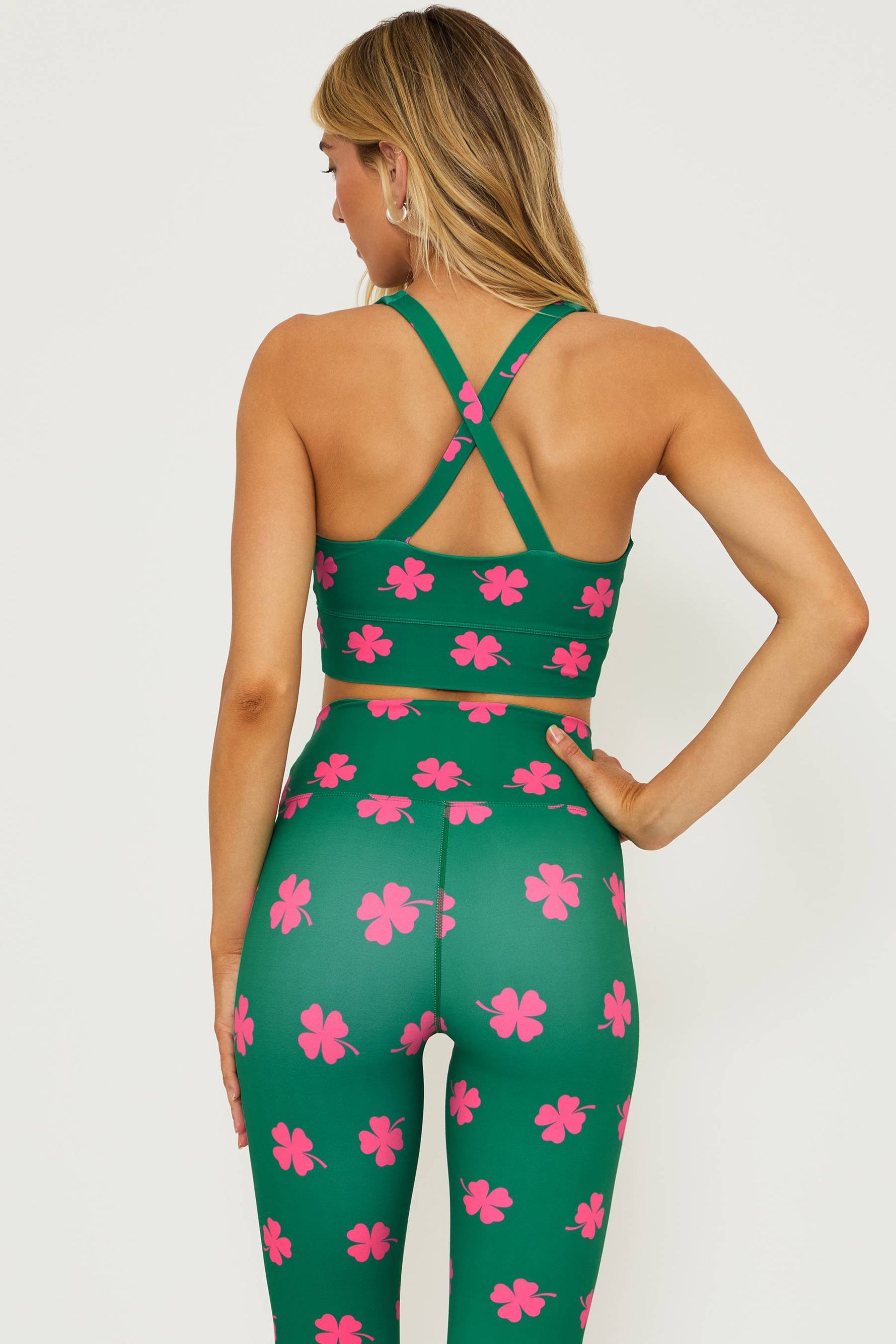 green sports bra with a pink clover print all over