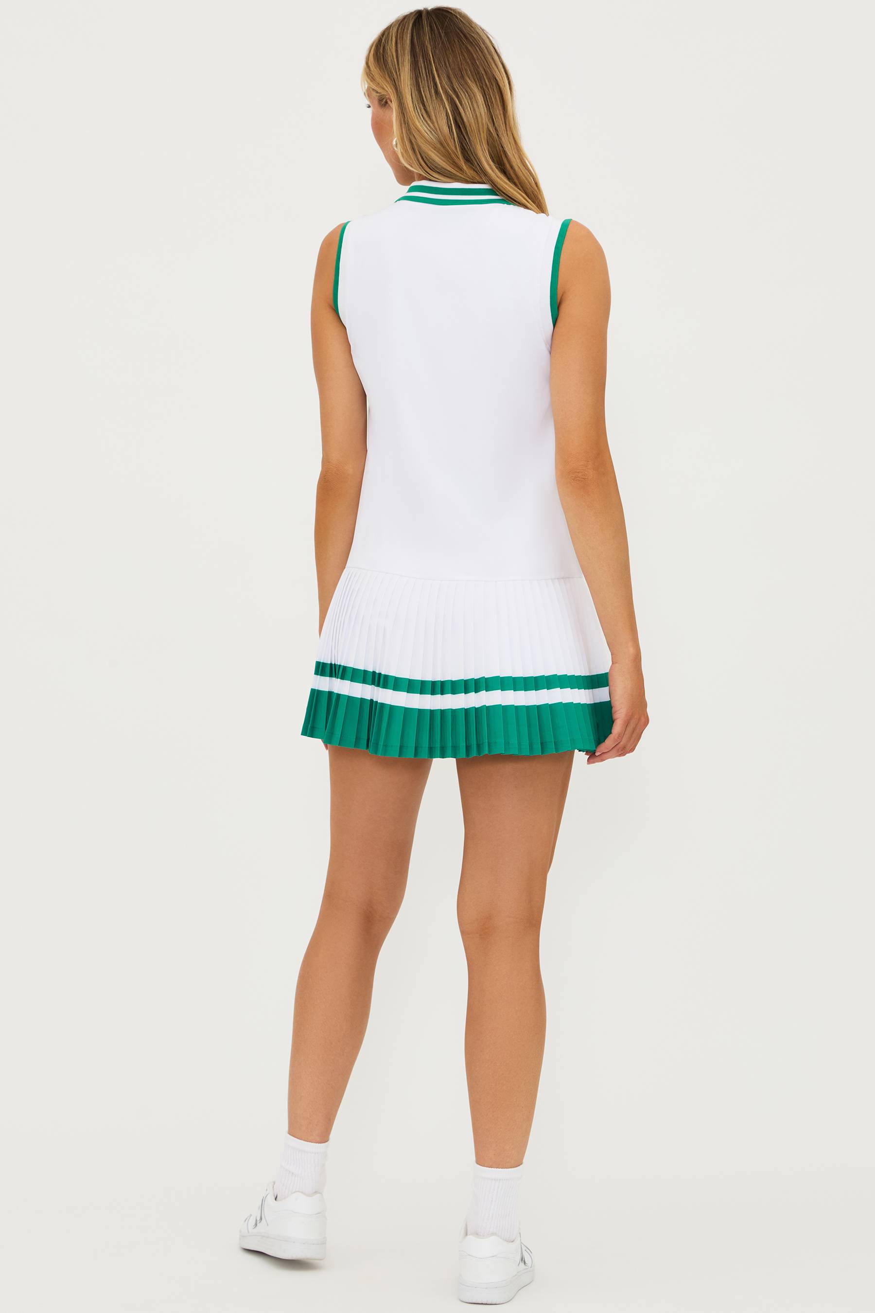 white pleated tennis dress with green stripes at the bottom