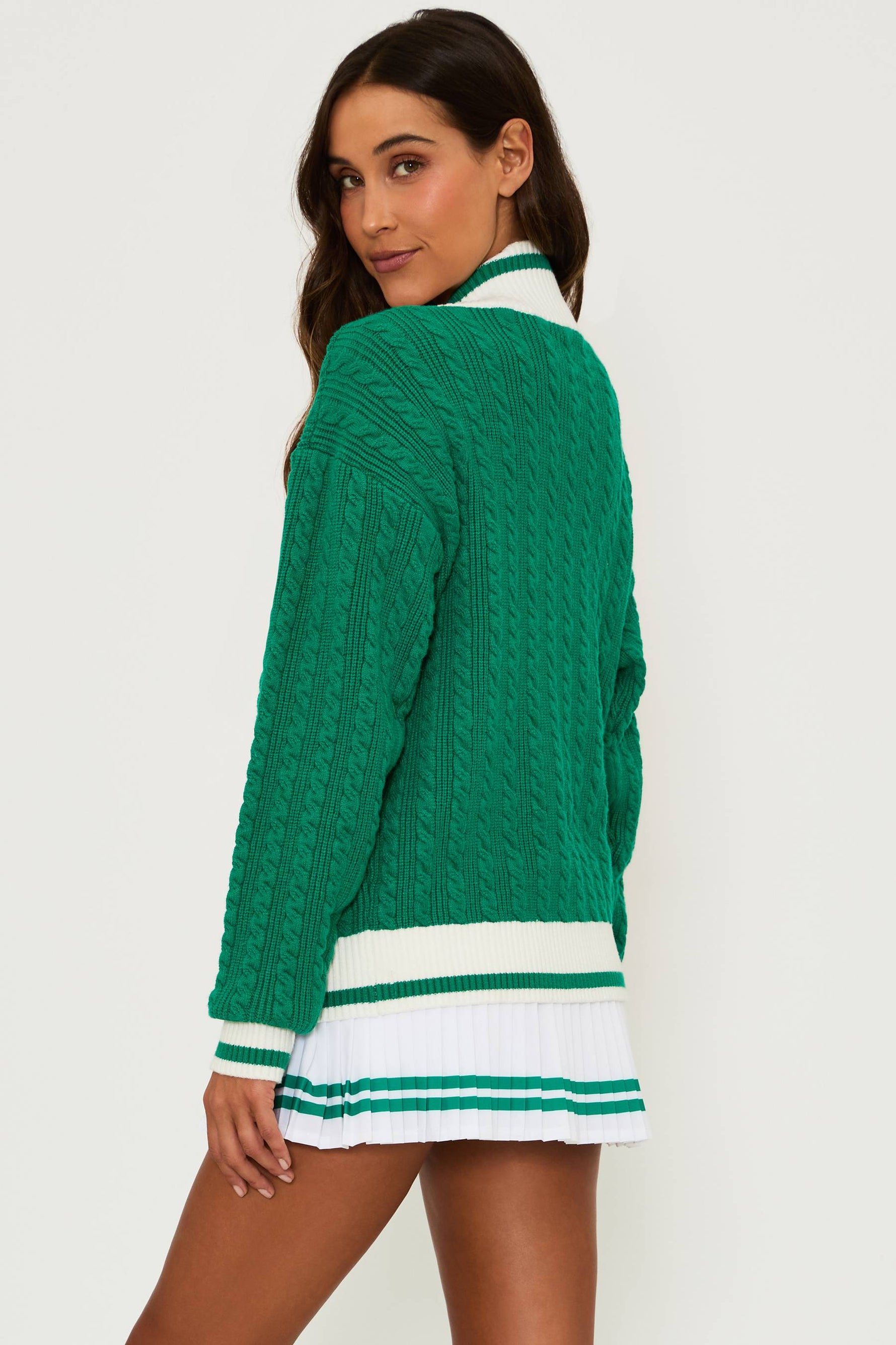 Oversized green cable knit sweater with a  neck and white ribbed cuffs and hem