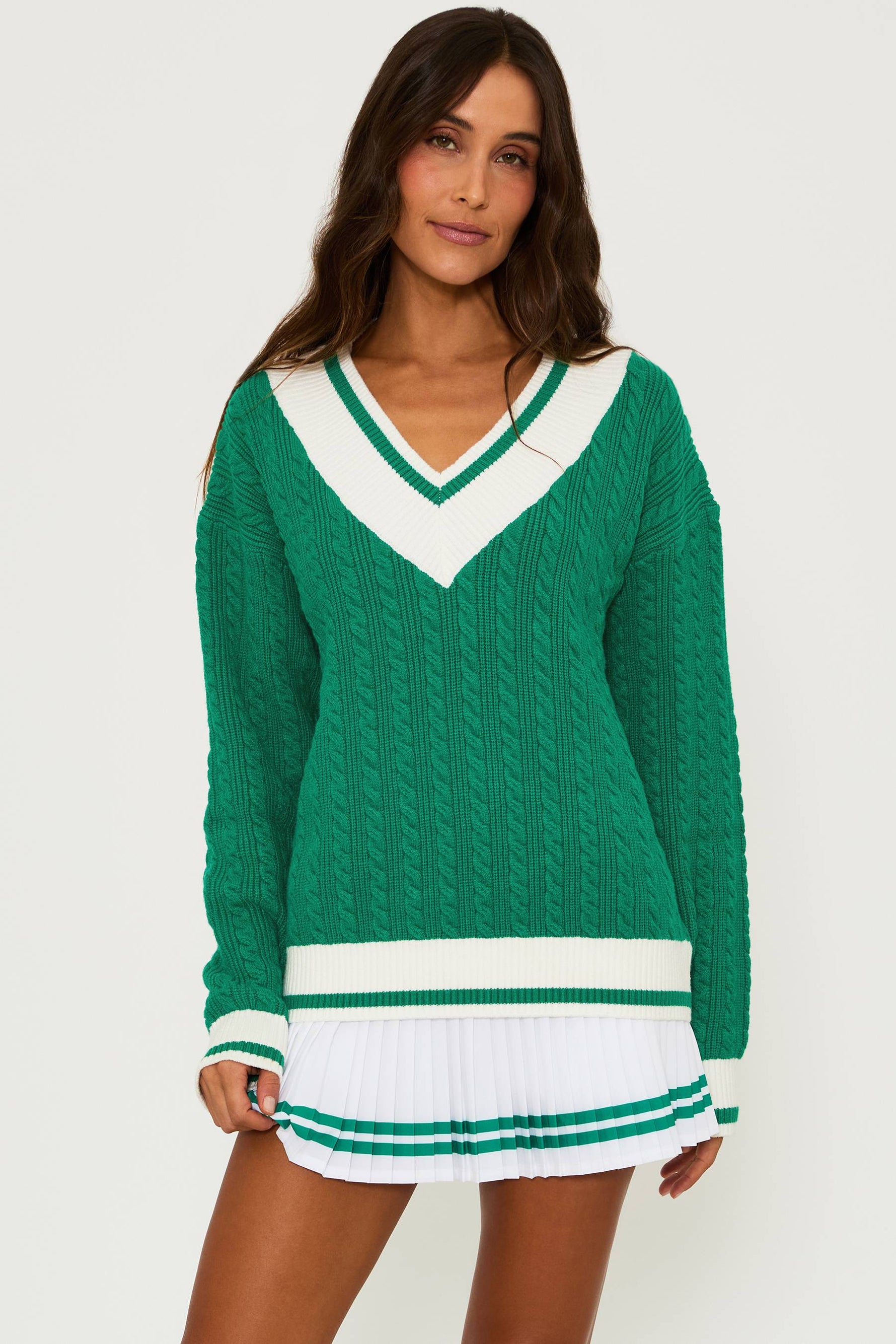 Oversized green cable knit sweater with a  neck and white ribbed cuffs and hem