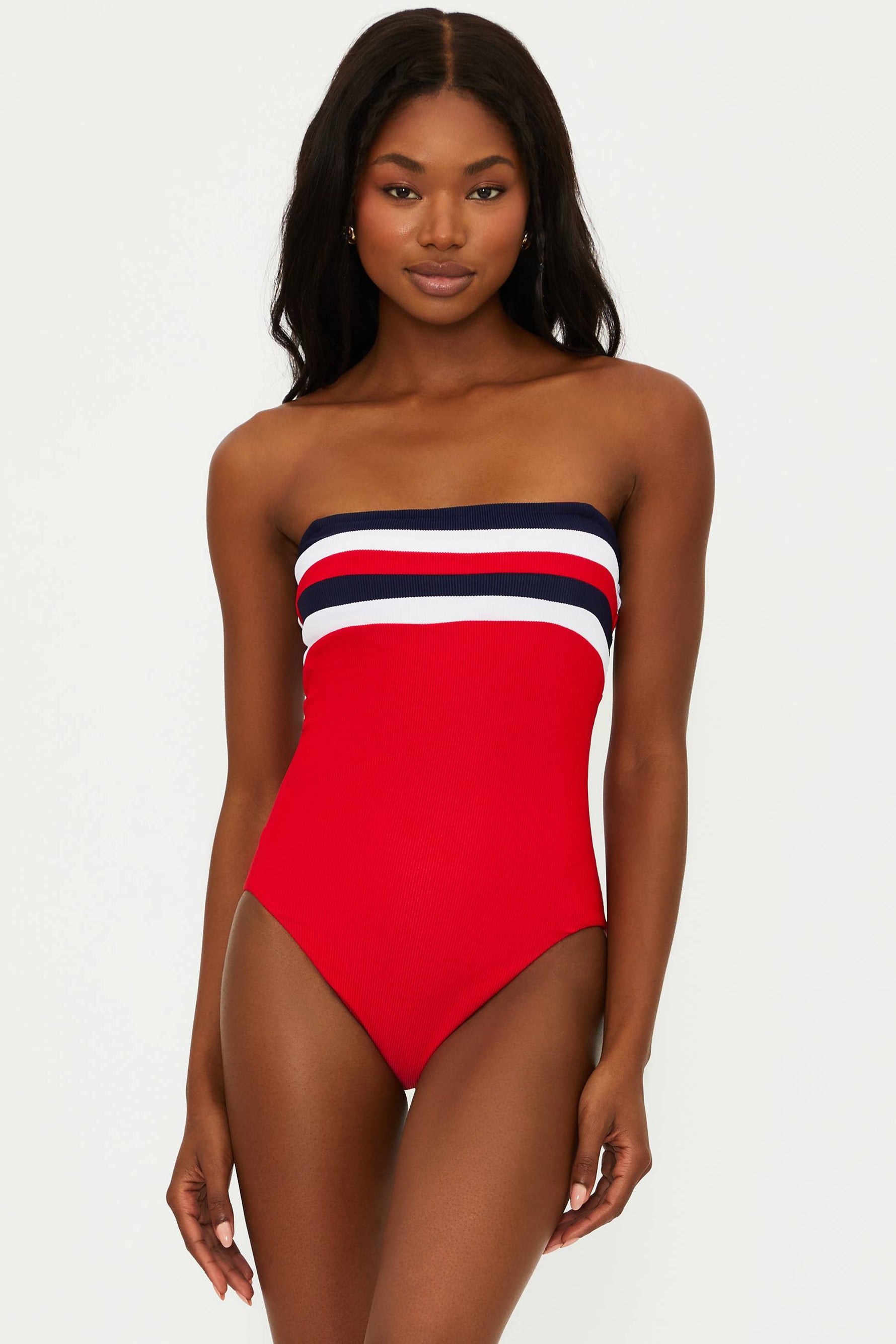 A model wearing a red, white, and blue one-piece swimsuit with a colorblock design.
