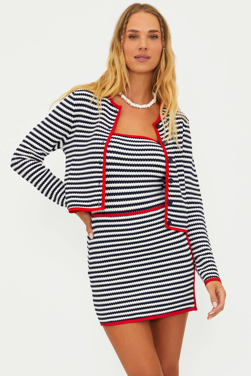 A female model wearing a striped cover-up with a cardigan-style top and red contrast trim.