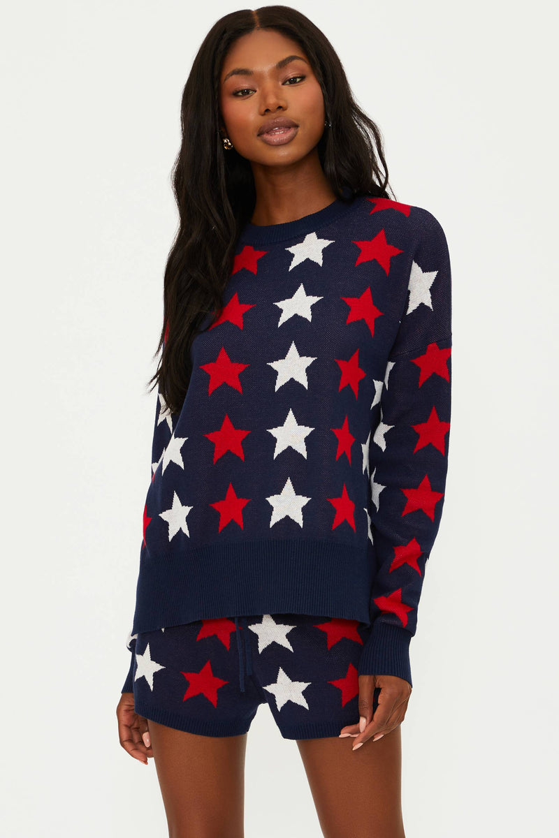 A woman wearing a blue and red star-patterned sweater and matching shorts.