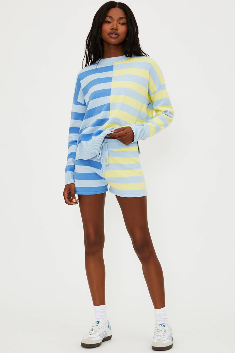Person wearing a colorful striped sweater and shorts set on a white background