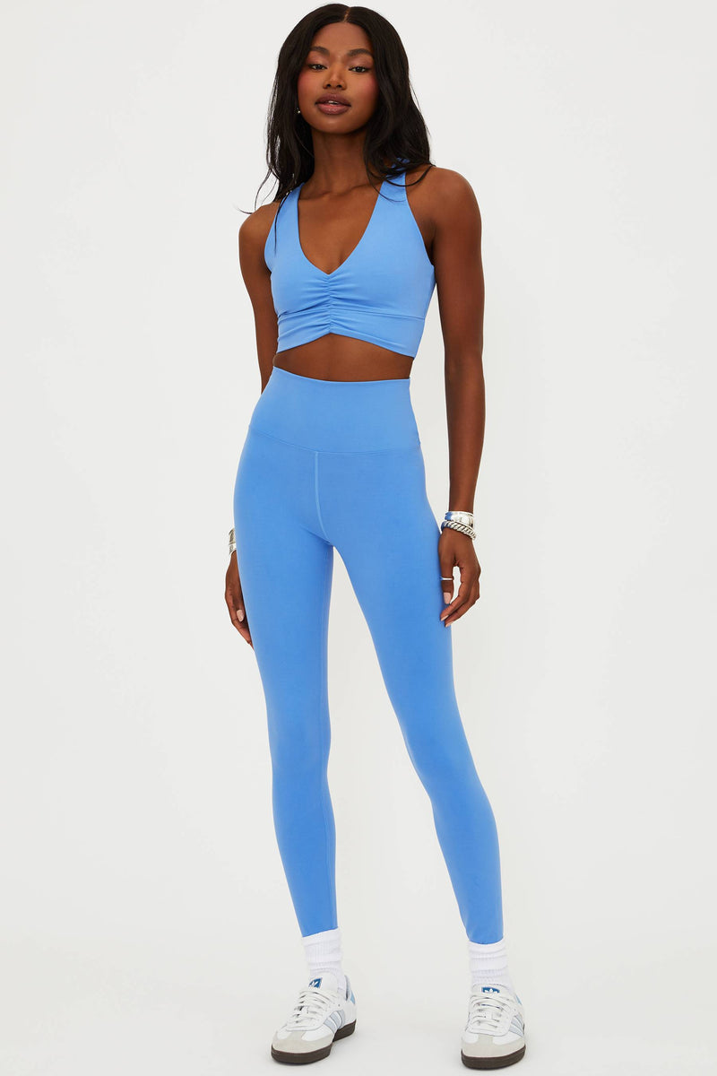 Woman wearing a blue athletic outfit on a white background