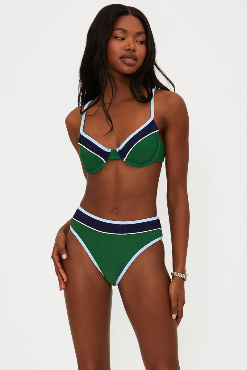 Woman wearing a green and navy bikini against a white background