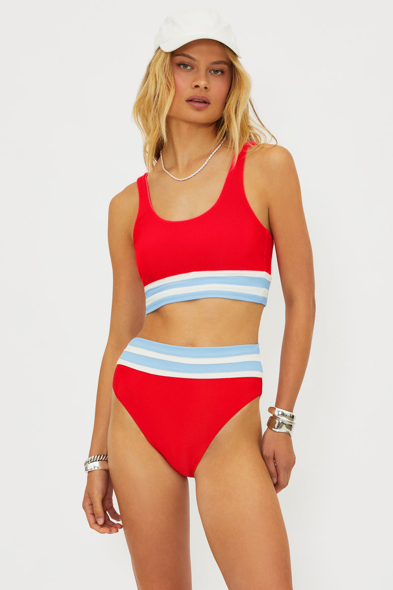 Woman wearing a red bikini with blue stripes on a white background