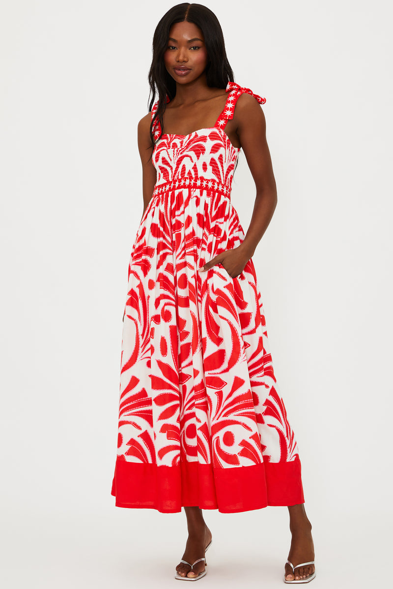Woman wearing a red and white patterned dress on a white background