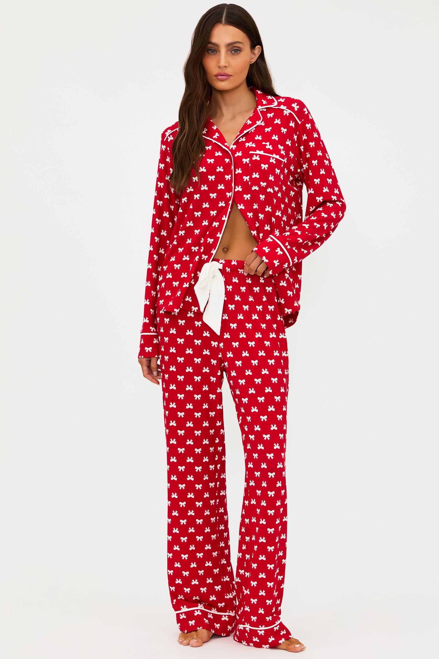 Woman wearing a red and white patterned pajama set on a white background