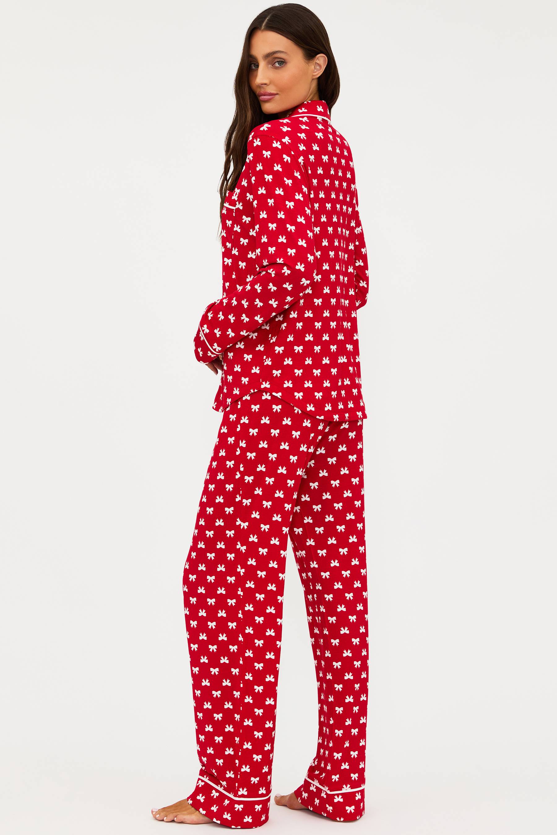 Woman wearing red pajamas with white patterns on a white background