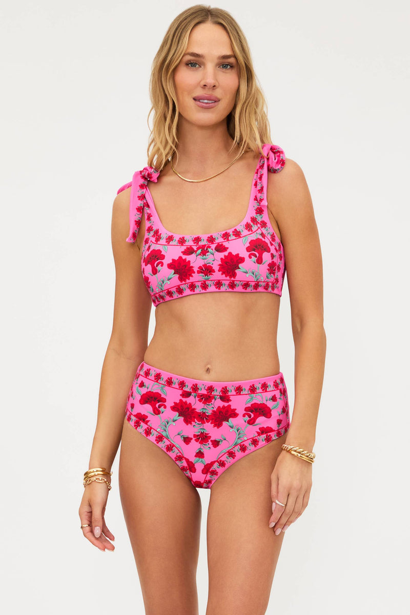 Woman wearing a pink floral bikini set on a white background
