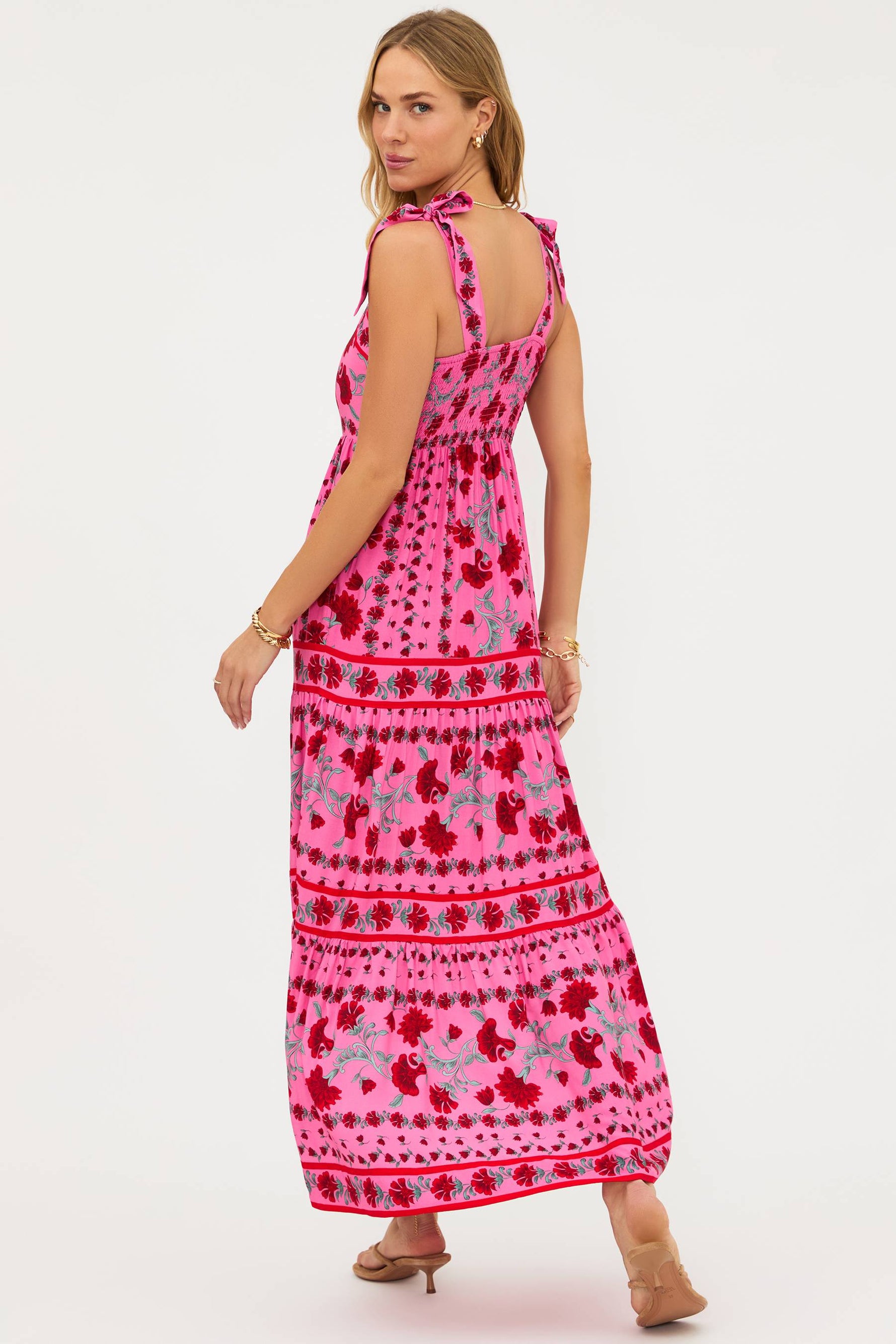 Woman wearing a pink patterned dress on a white background