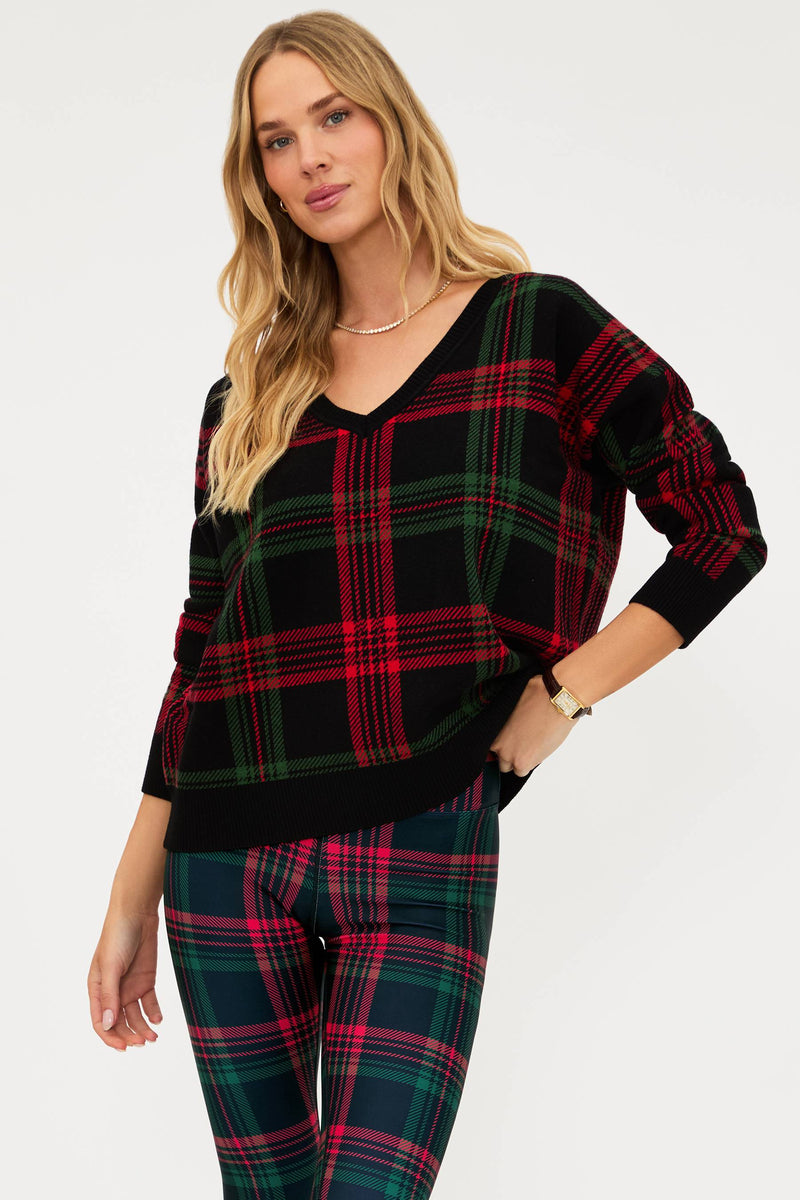 Woman wearing a black and red plaid sweater with matching pants on a white background