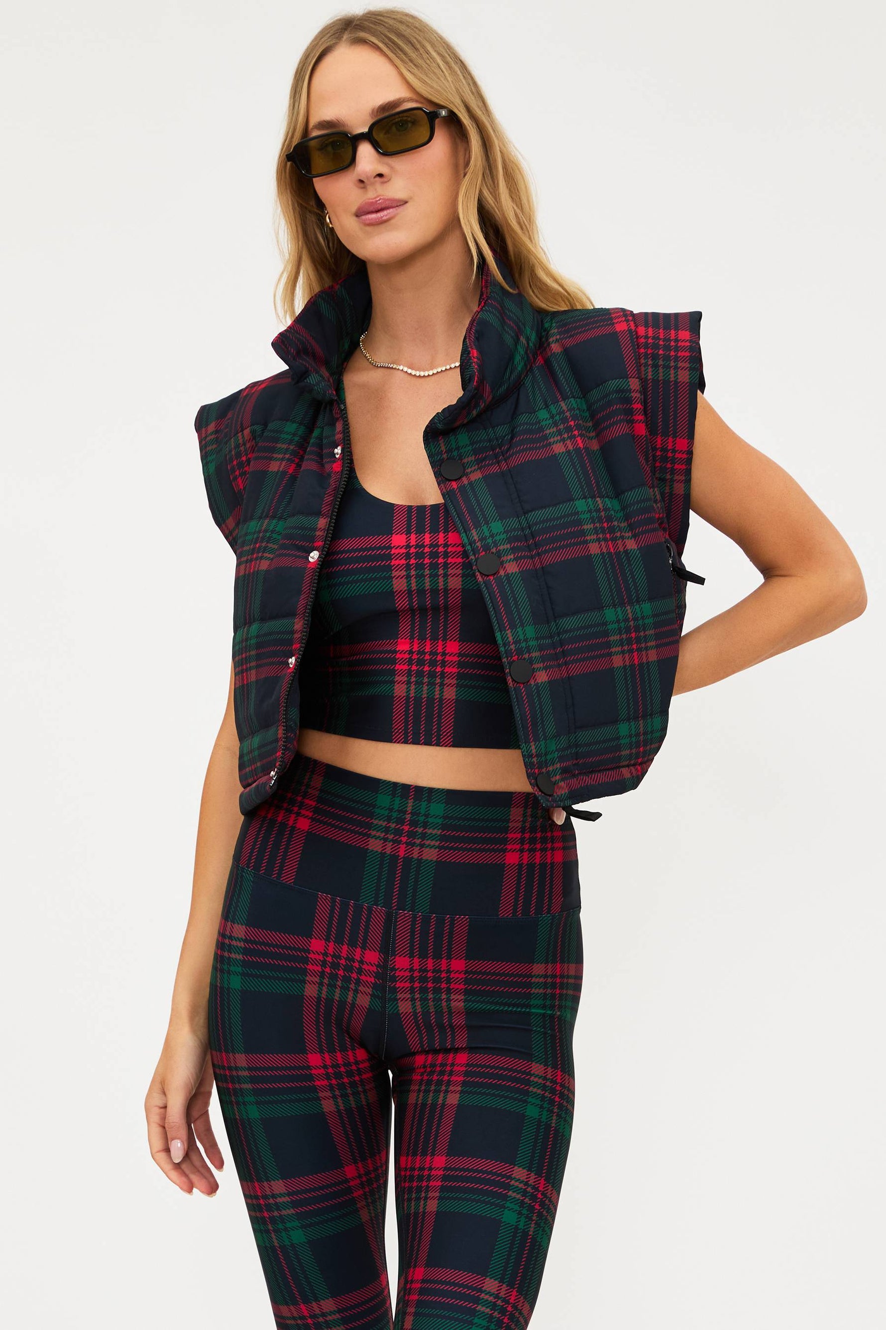 Woman wearing a plaid outfit with a vest on a white background