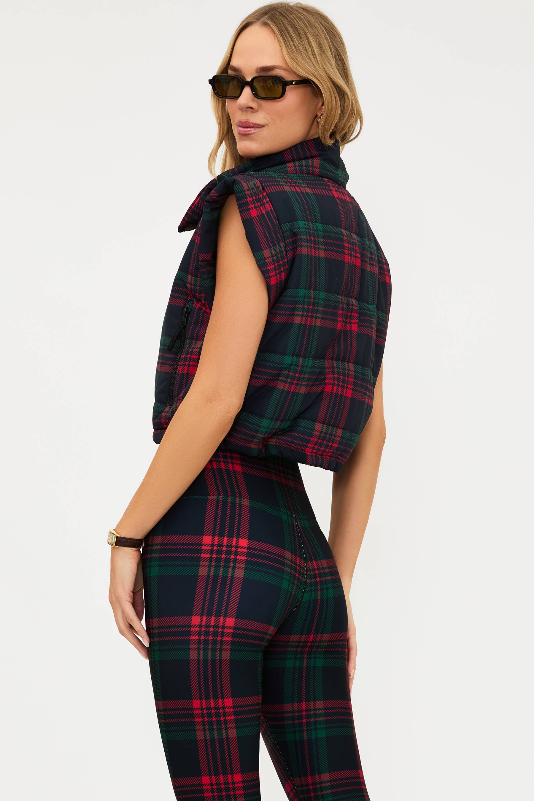 Woman wearing a red and green plaid outfit on a white background
