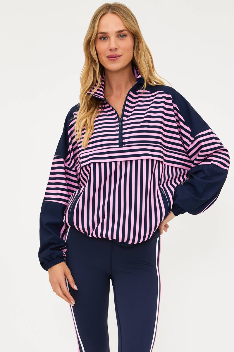 Woman wearing a striped shirt and navy pants on a white background