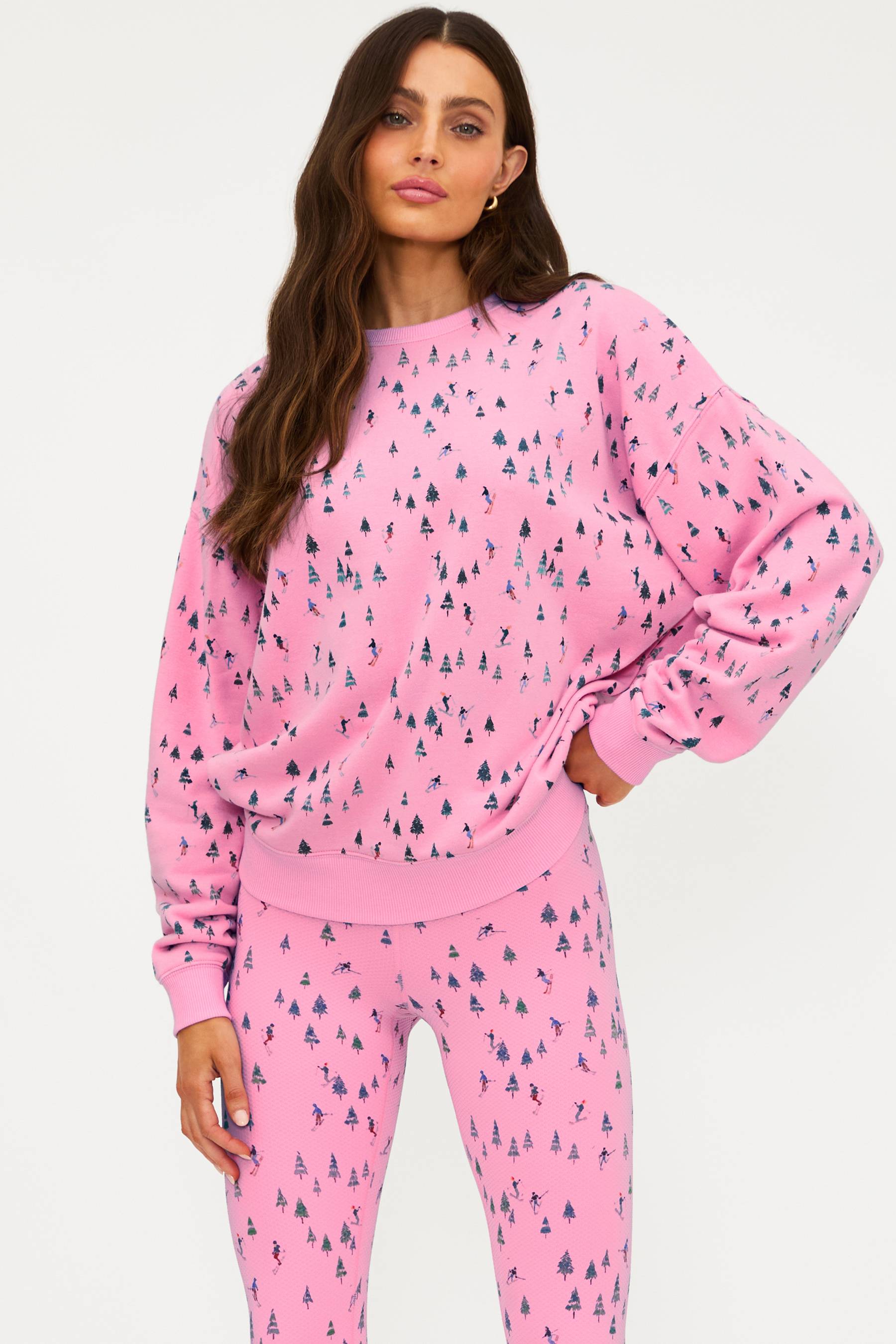 Woman wearing a pink pajama set with a pattern on a white background