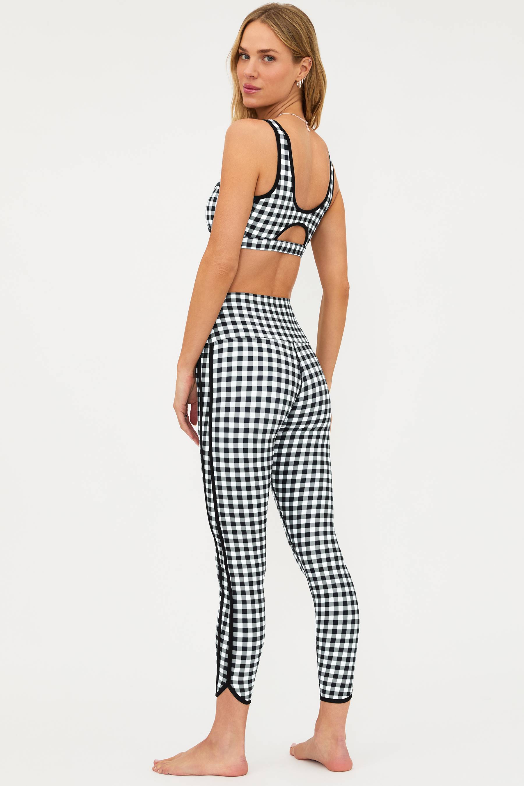 Woman wearing a black and white checkered outfit on a white background