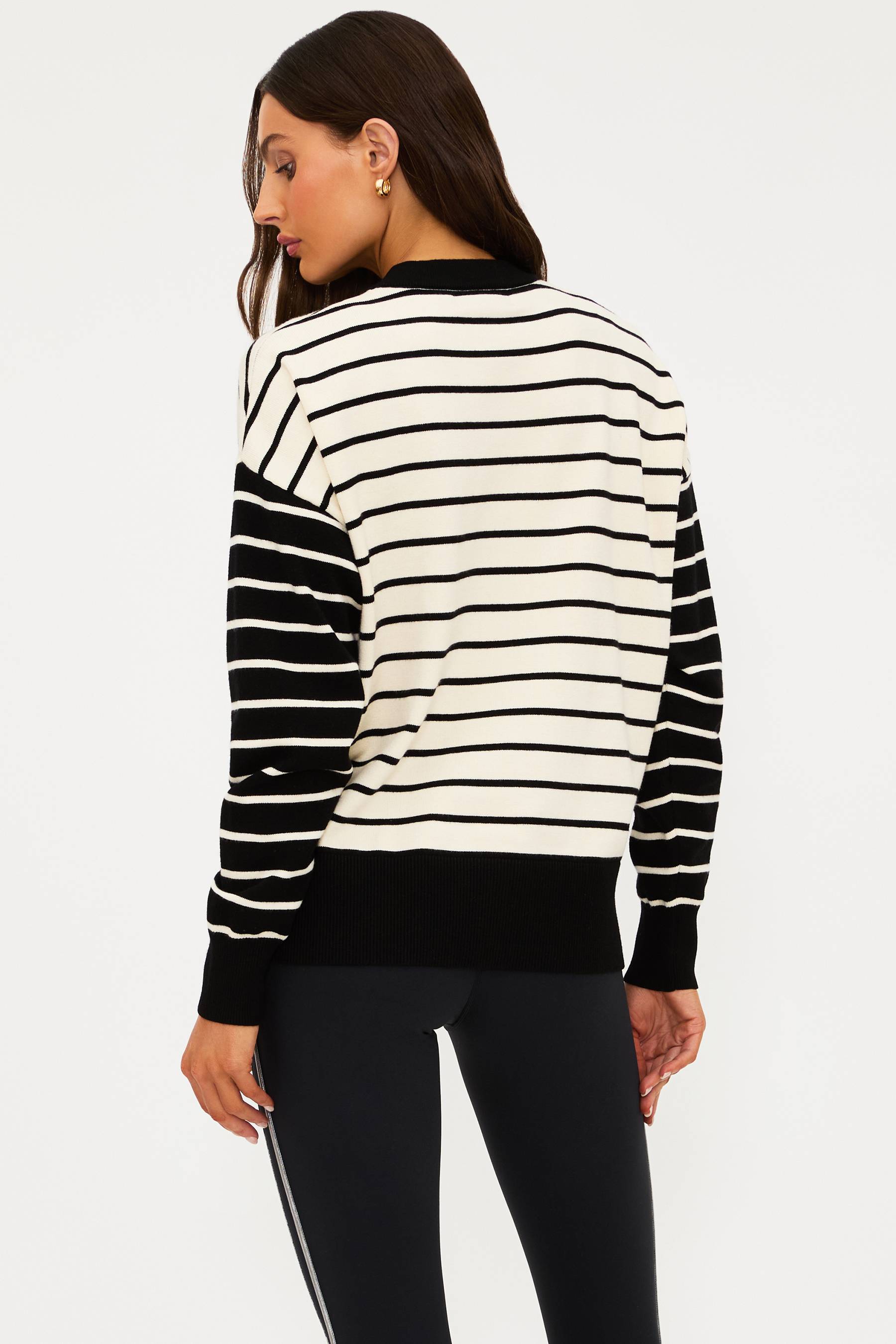 Woman wearing a black and white striped sweater on a plain background