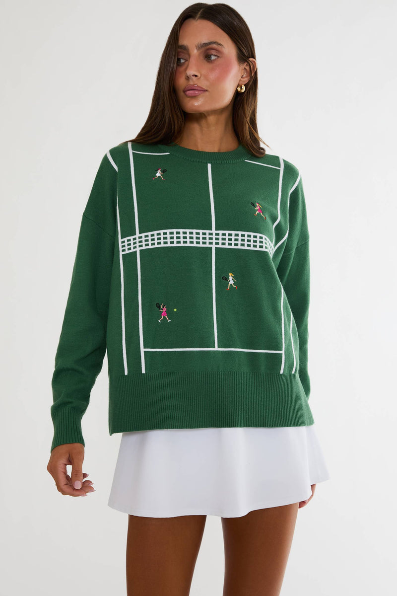 Woman wearing a green sweater with tennis court design on a white background