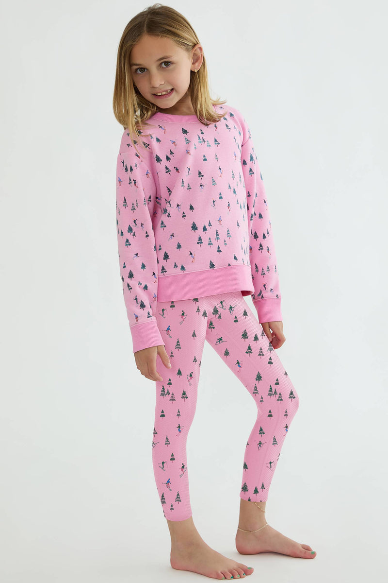 Young girl wearing pink pajamas with a pattern on a white background