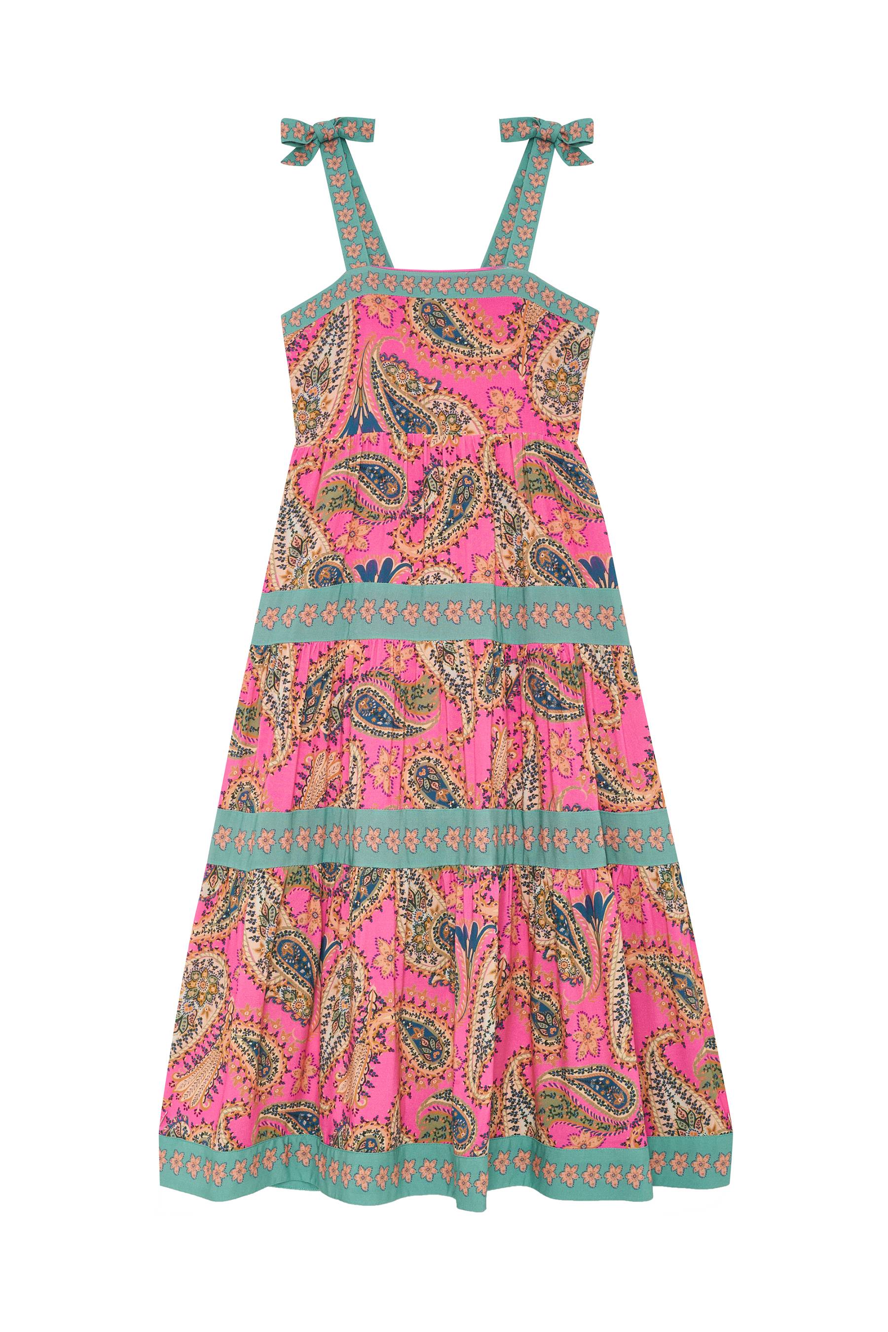 A sleeveless tiered maxi dress with a vibrant pink paisley pattern, teal and gold borders, and tie-shoulder straps, shown against a plain white background.