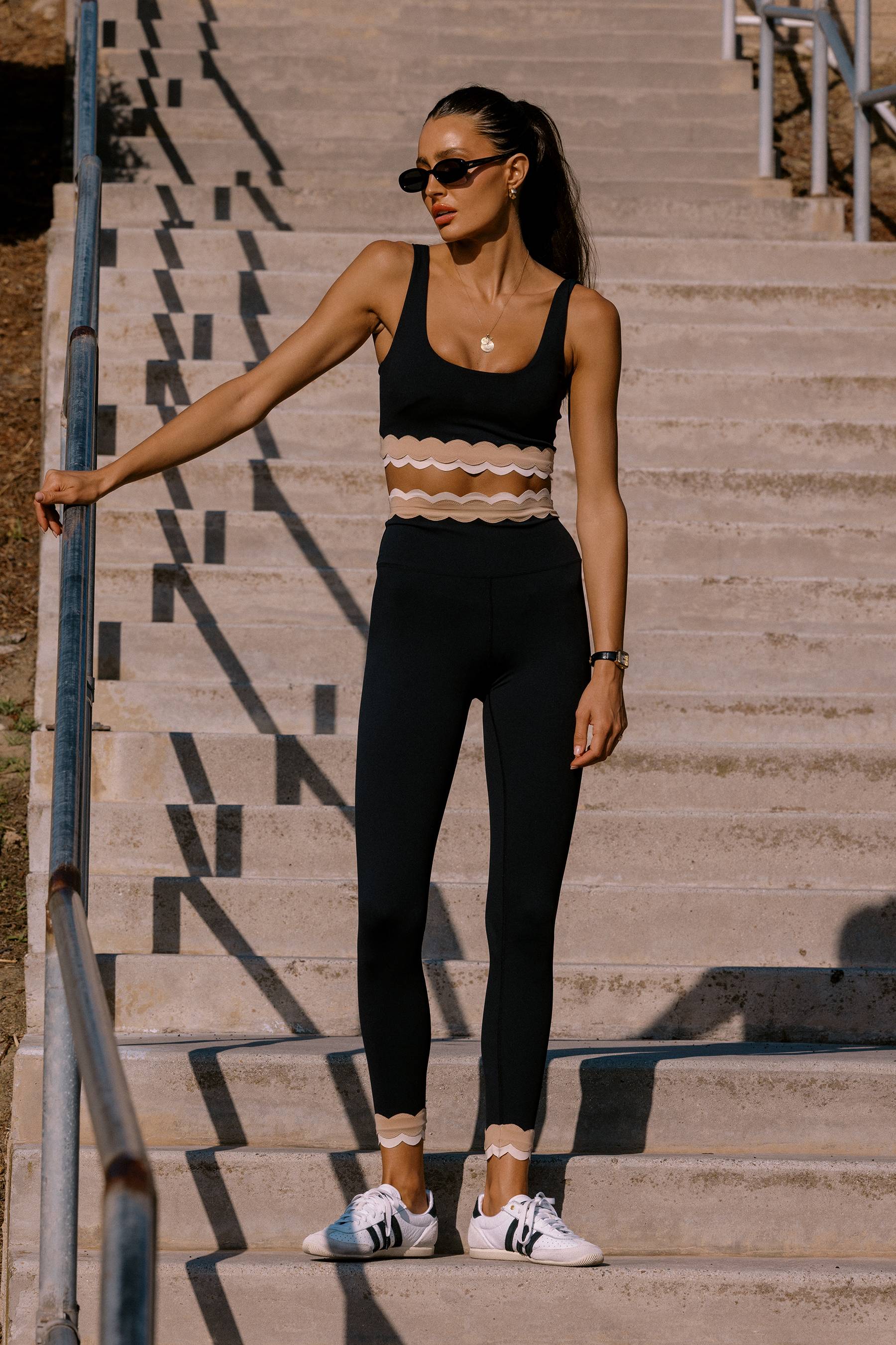 Woman in athletic wear standing on a set of stairs