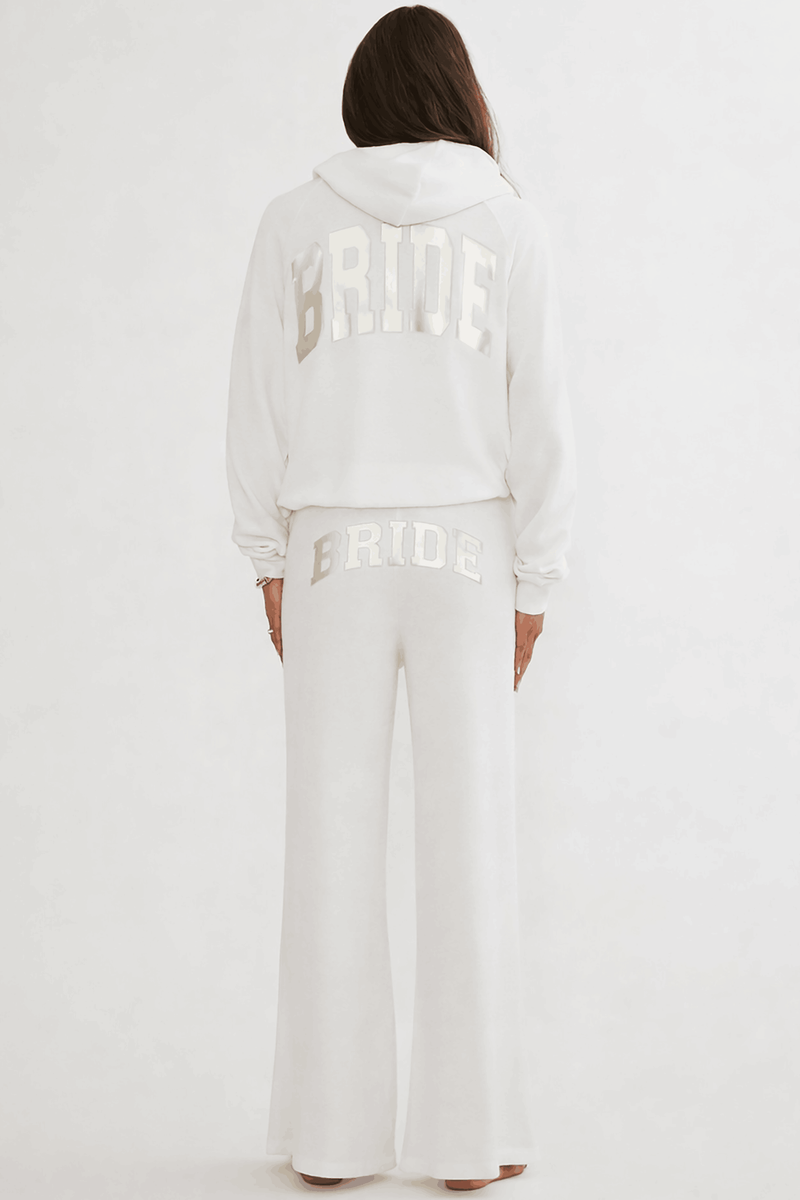 Person wearing a white 'BRIDE' jacket and pants on a white background
