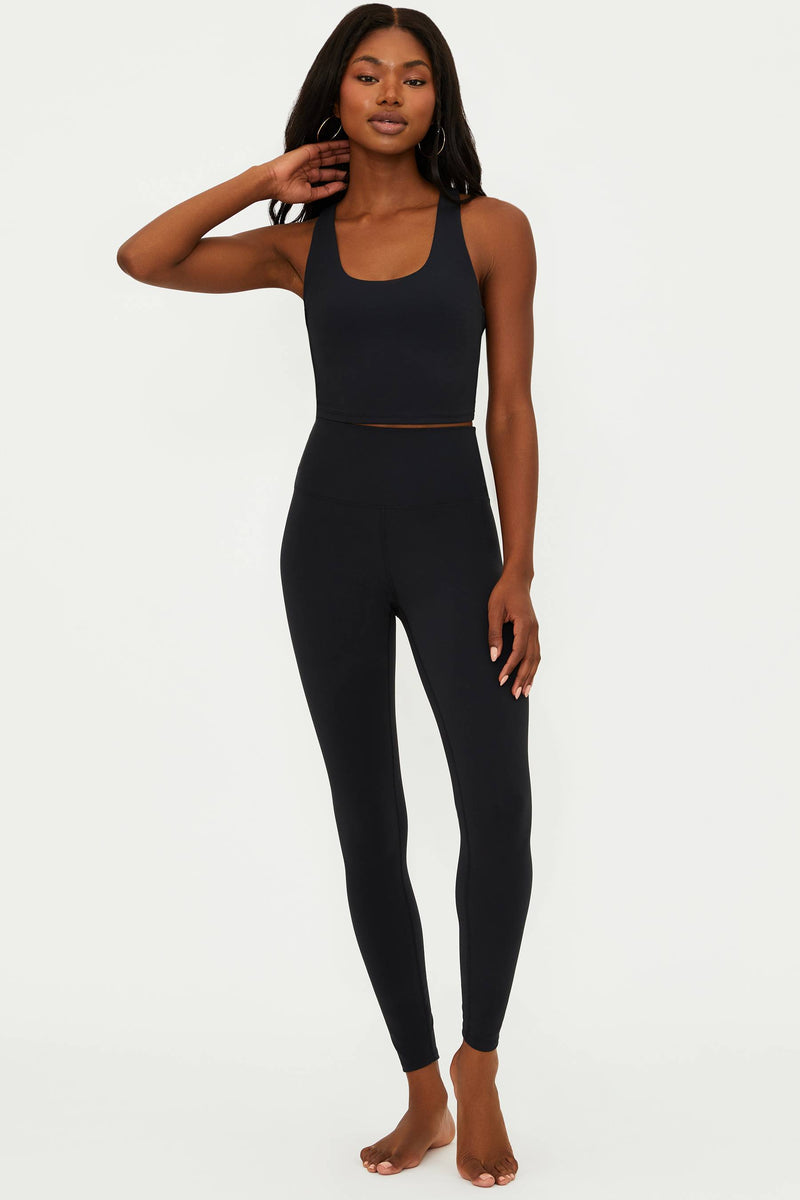 A model wearing black matte Piper legging and matching top, standing against a neutral background.