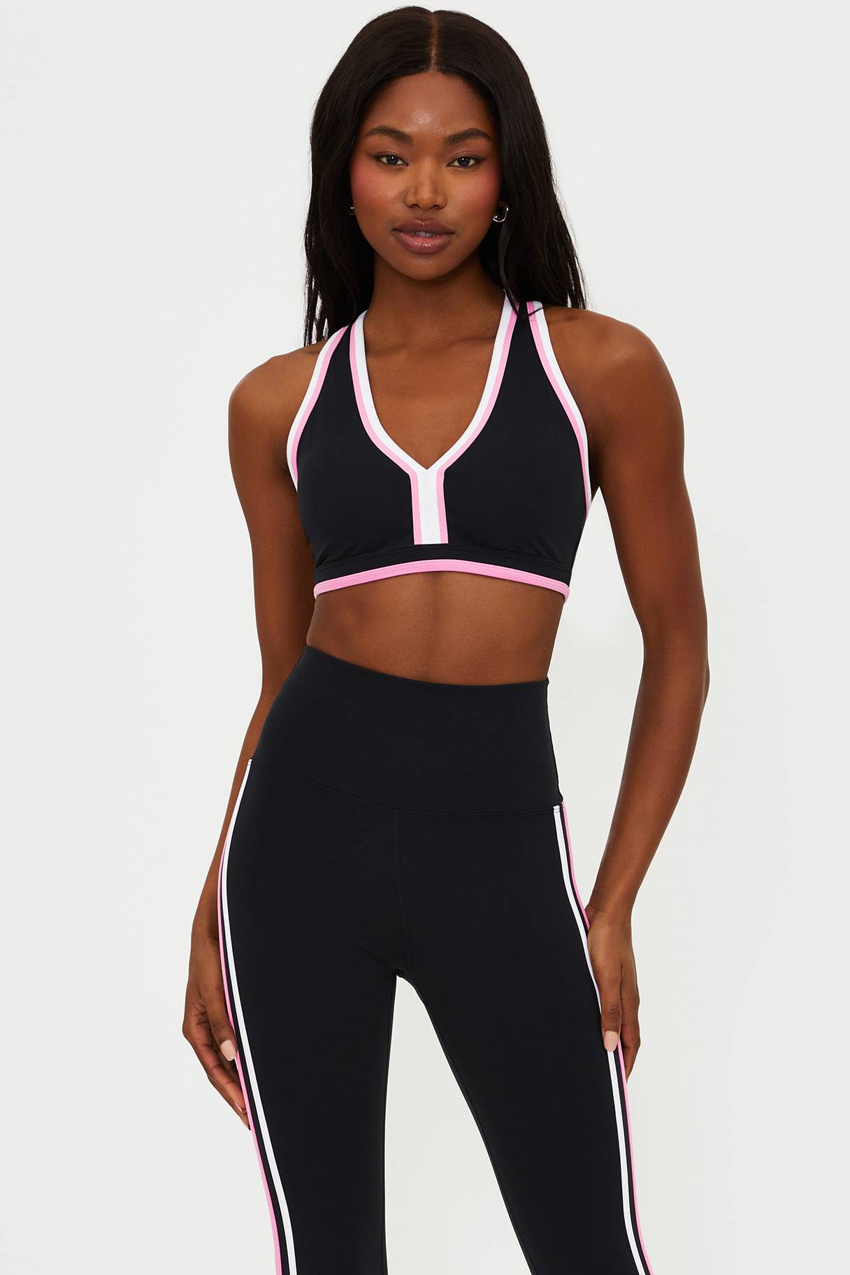 black scoop neck racer back sports bra with pink and white piping 