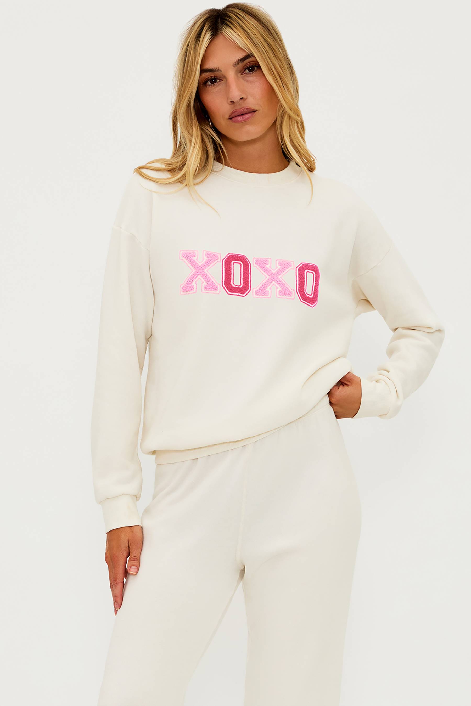 Ivory sweat pant with pink chenile hearts on the leg and pink xoxo graphic on the chest