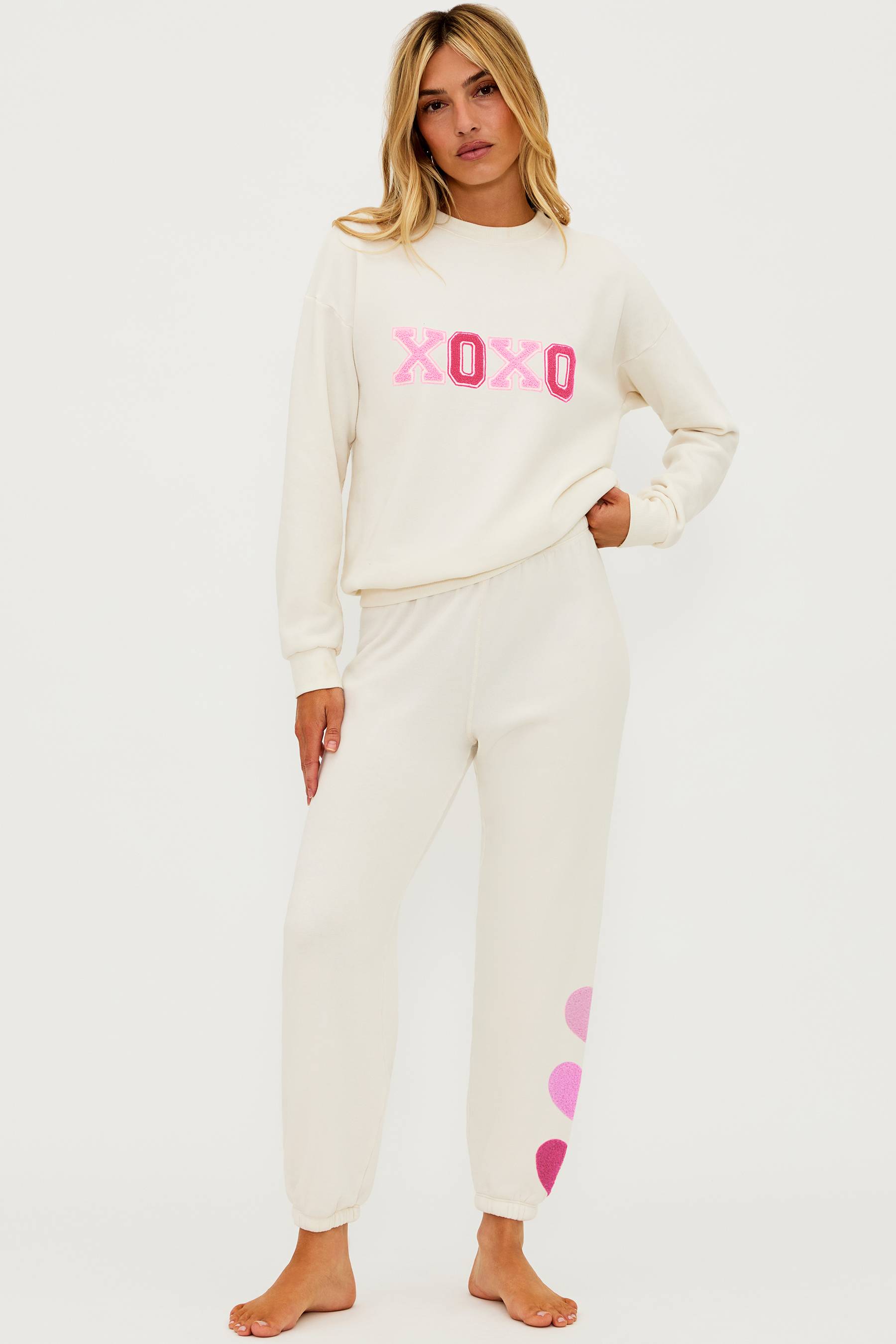 Ivory sweat pant with pink chenile hearts on the leg and pink xoxo graphic on the chest