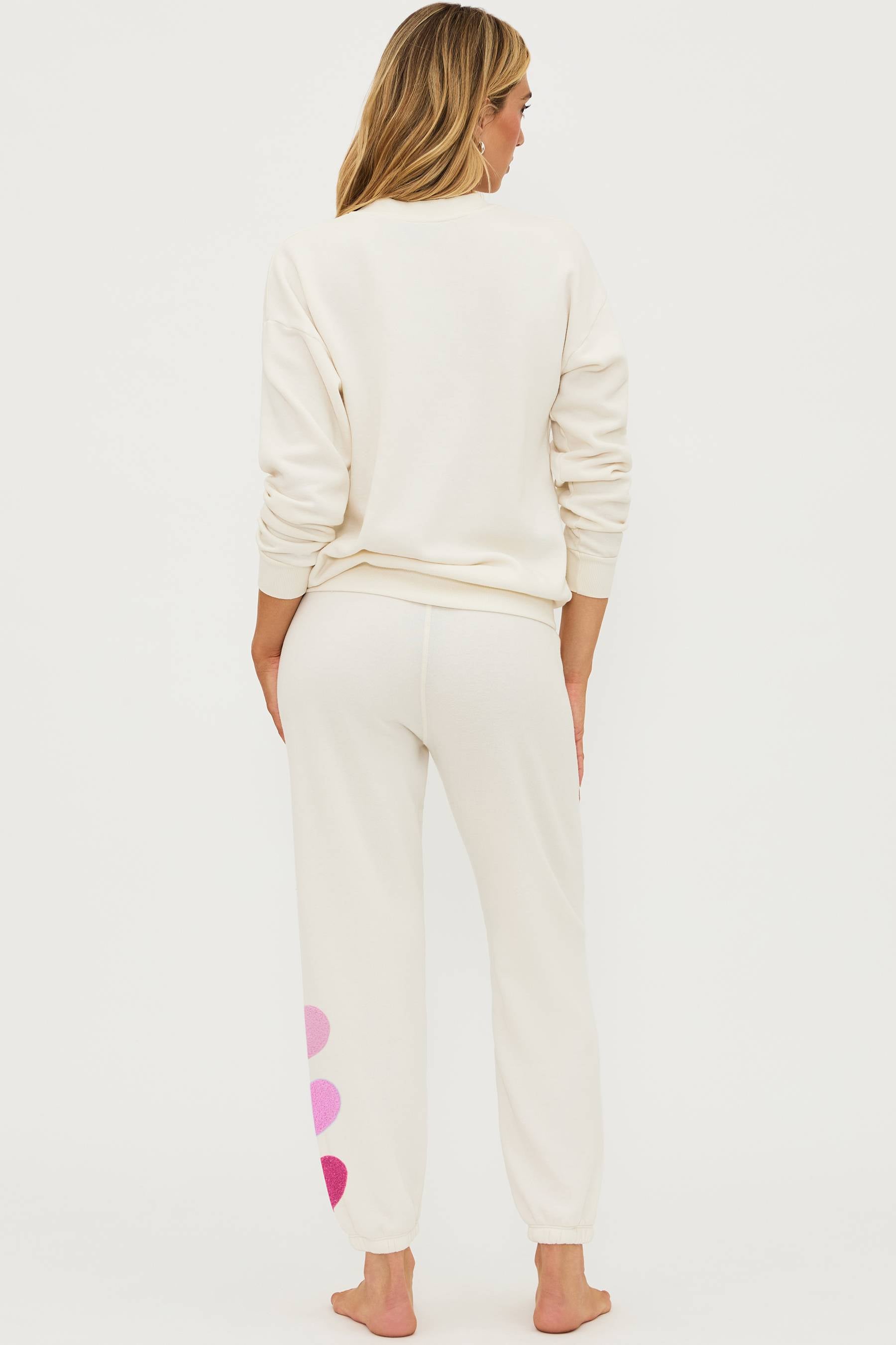 Ivory sweat pant with pink chenile hearts on the leg and pink xoxo graphic on the chest