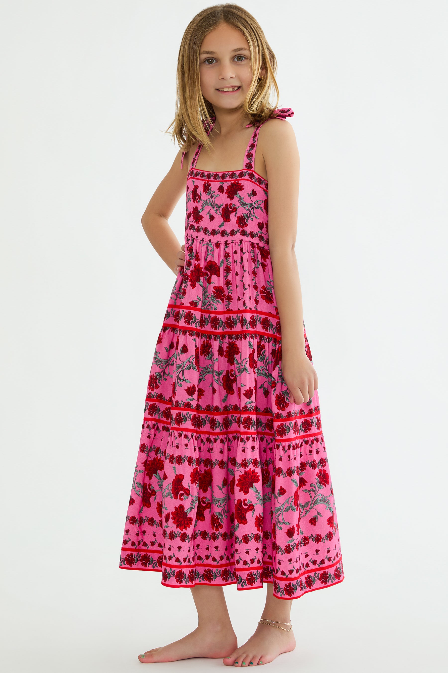 Young girl wearing a pink floral dress on a white background