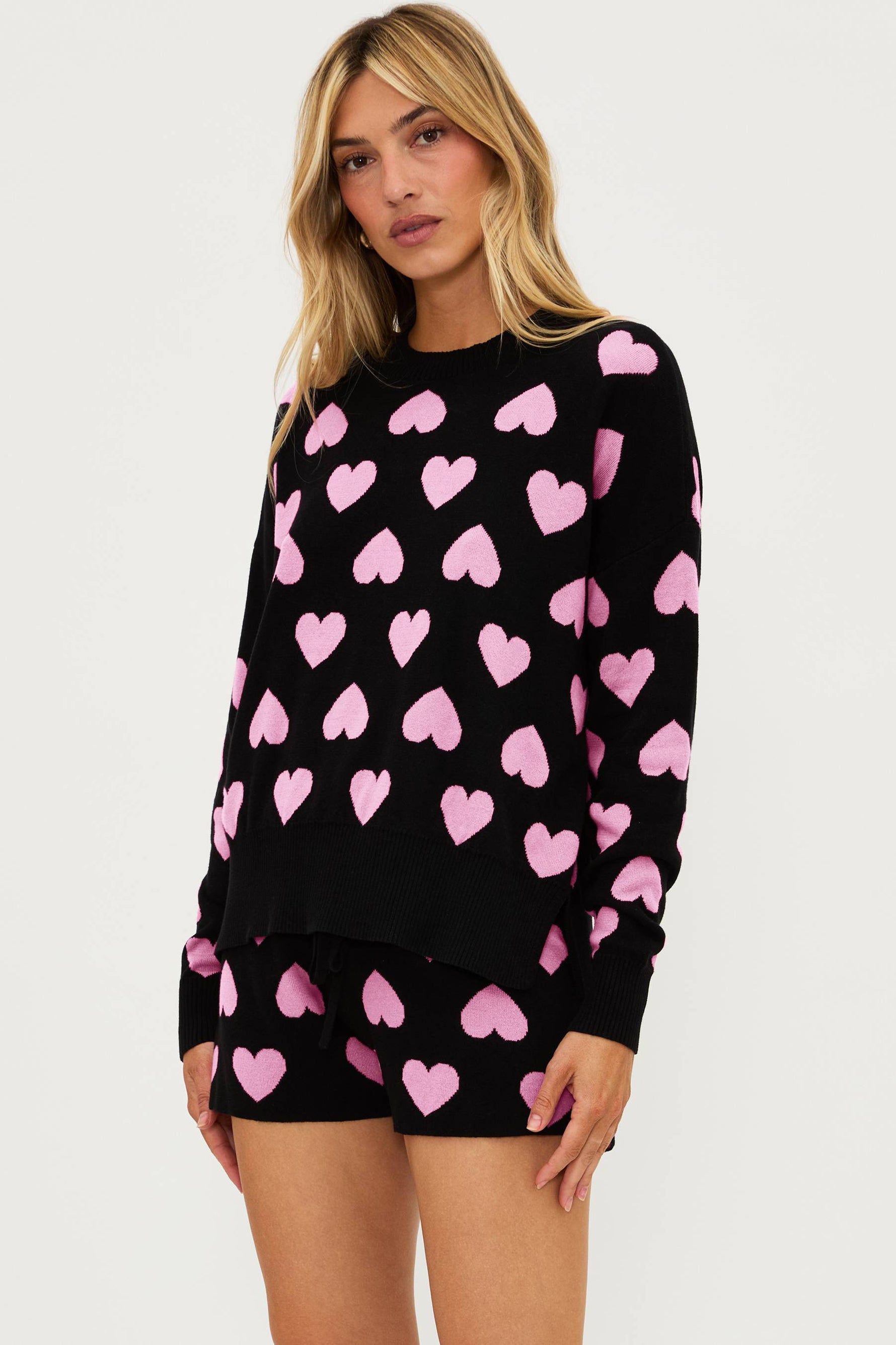 black sweater with pink heart print all over and matching black shorts with light pink hearts