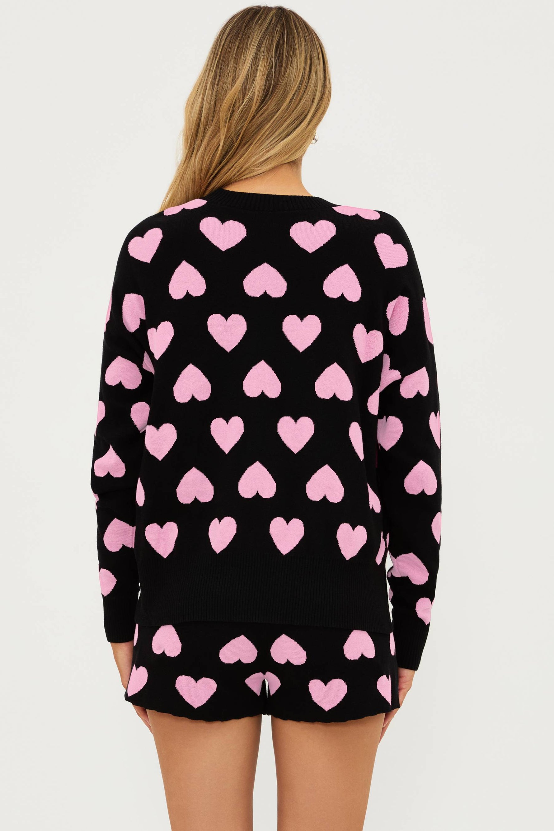 black sweater with pink heart print all over and matching black shorts with light pink hearts